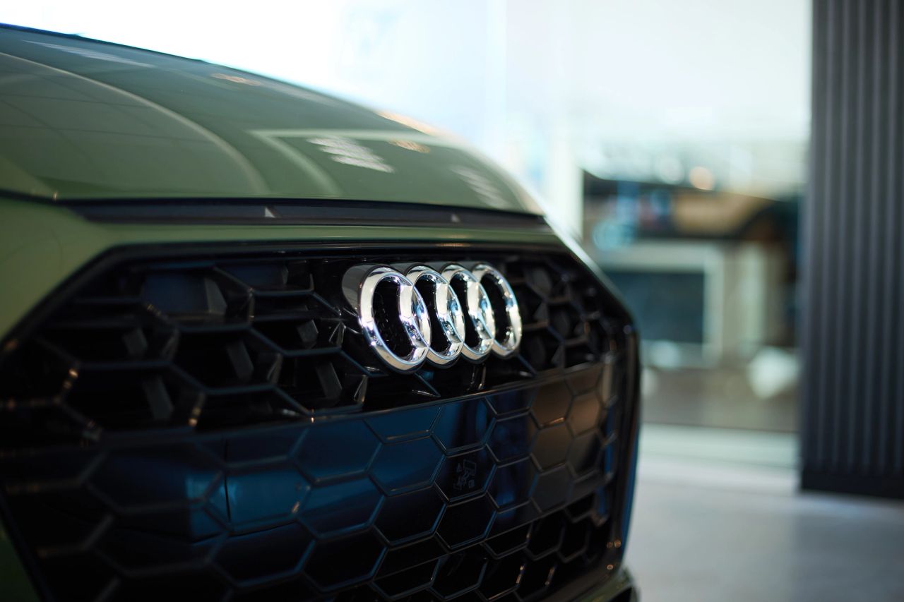 Close-up van de grill van een olijfgroene auto in de showroom.