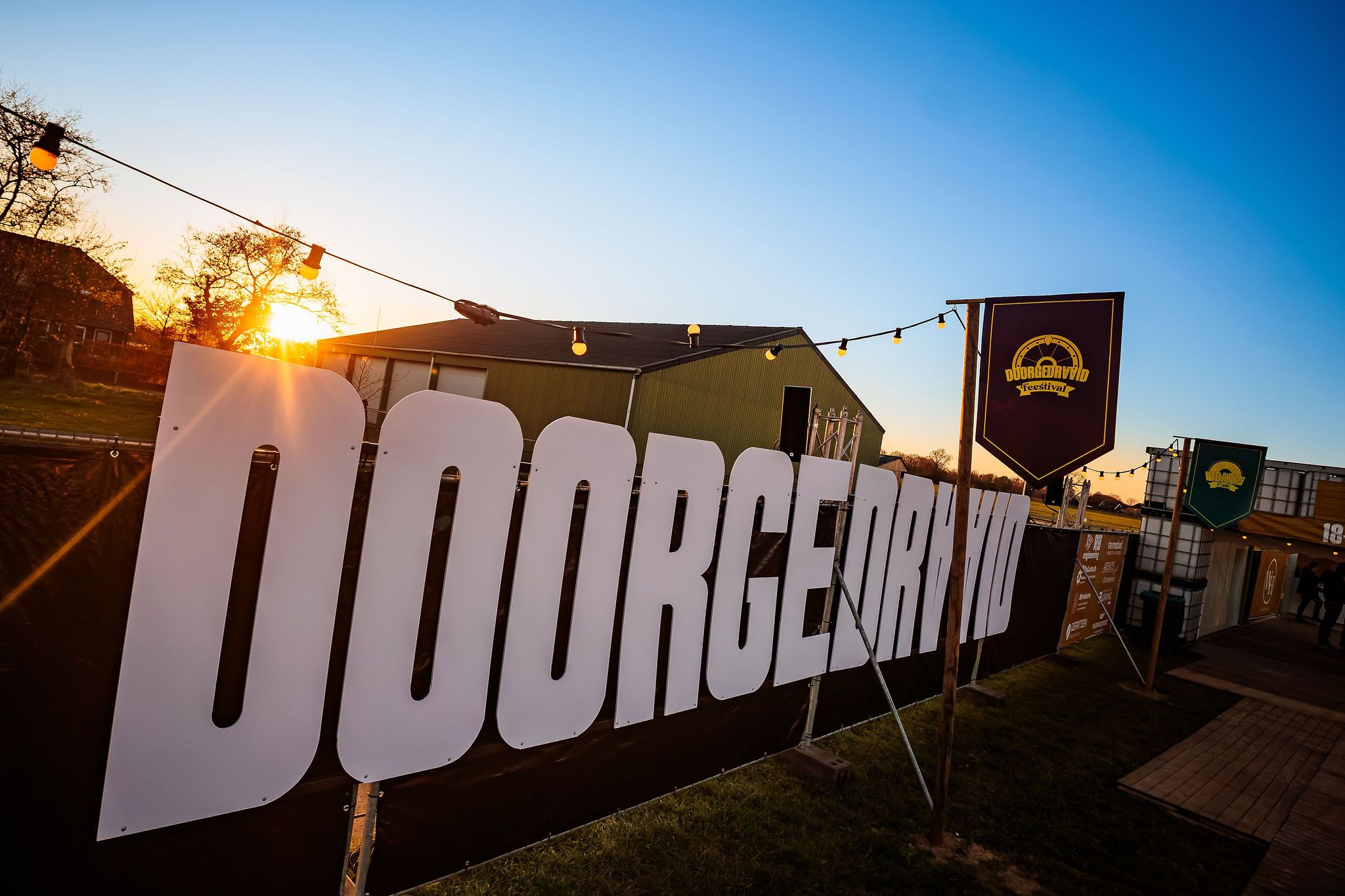 Groot Doorgedraaid-bord bij zonsondergang op het festivalterrein, gemaakt door Bold Productions