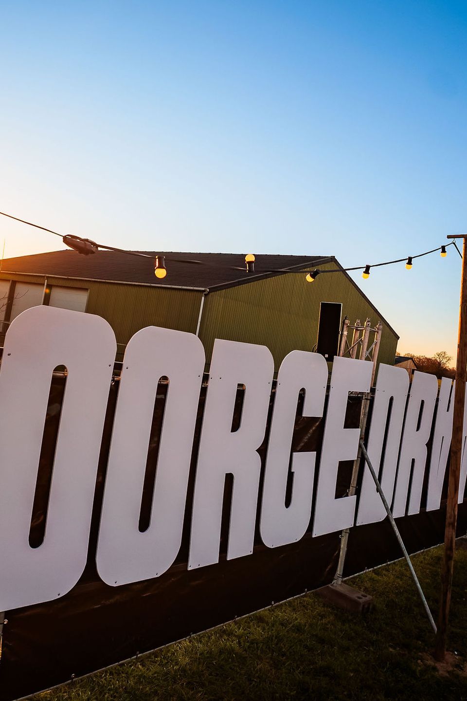 Groot Doorgedraaid-bord bij zonsondergang op het festivalterrein, gemaakt door Bold Productions