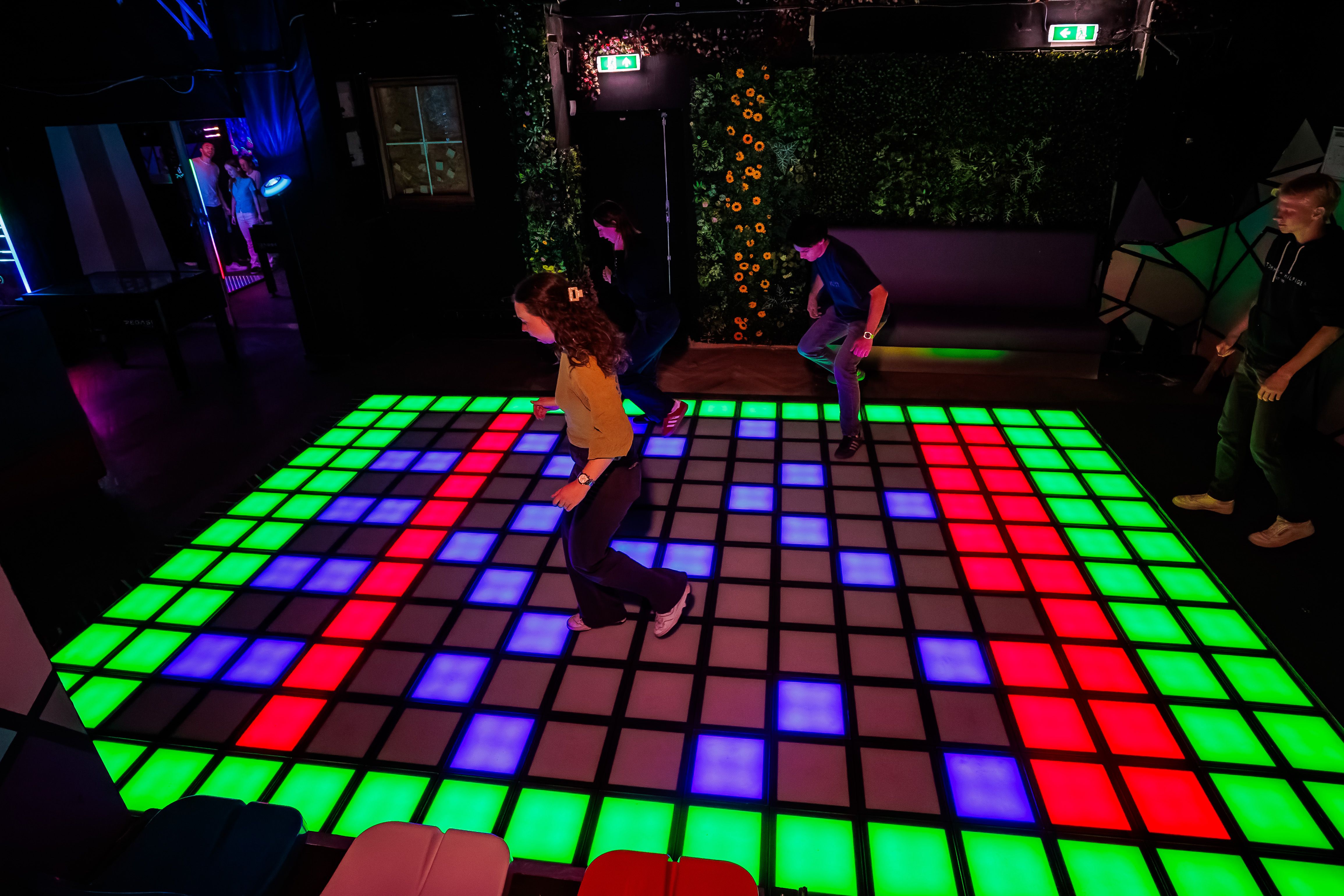 Gasten spelen op een grote led-vloer in groen, rood en blauw bij Timestamp Arnhem, gemaakt door Bold Productions