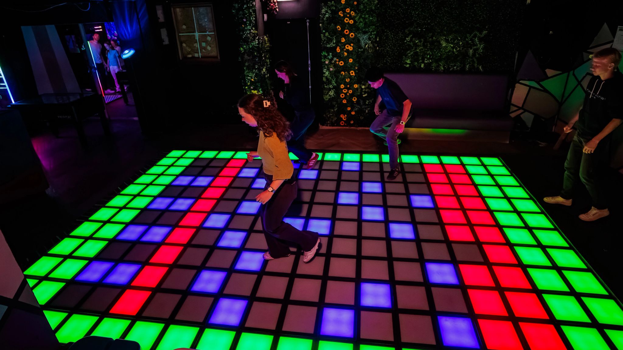 Gasten spelen op een grote led-vloer in groen, rood en blauw bij Timestamp Arnhem, gemaakt door Bold Productions