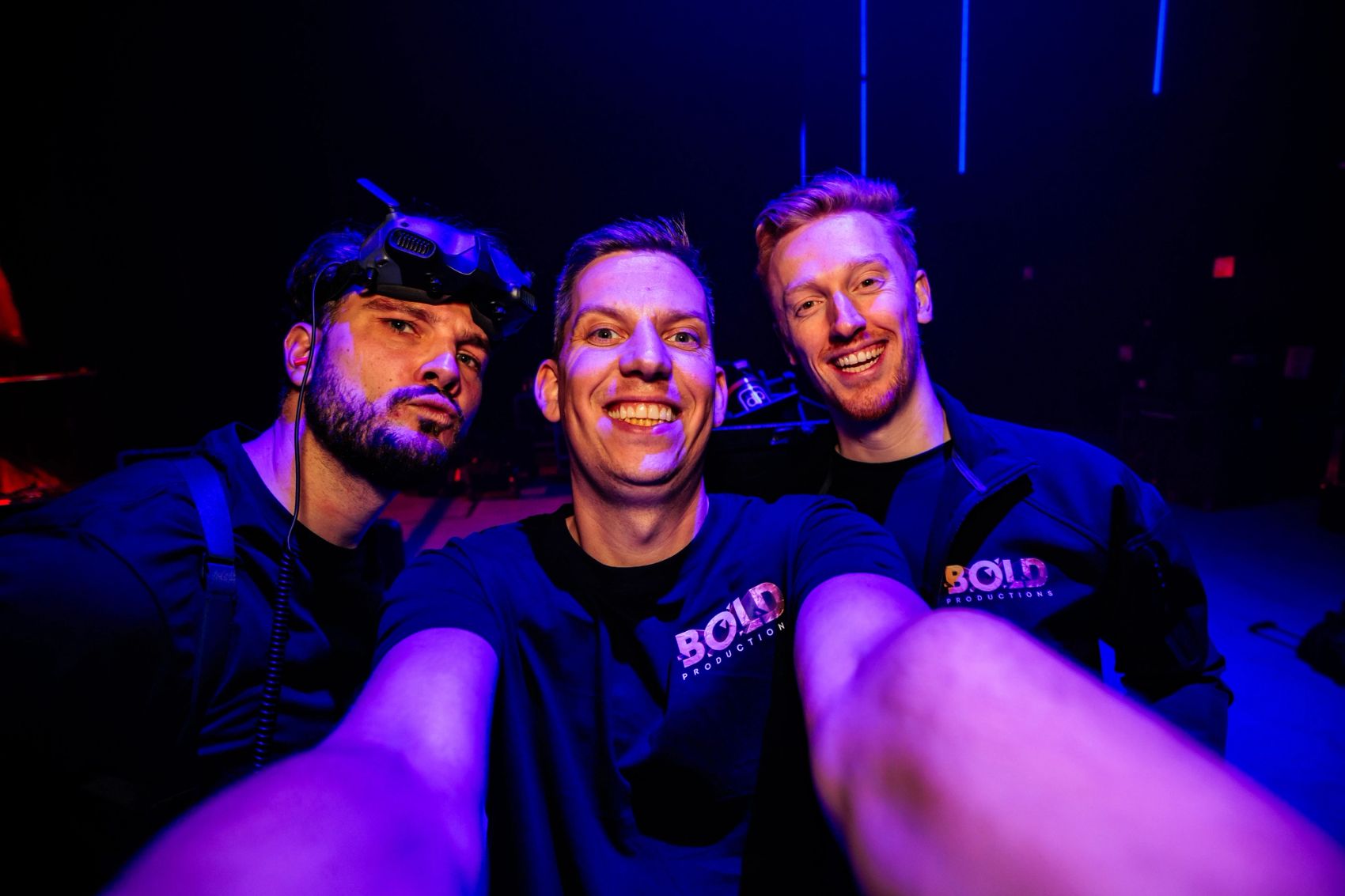 Selfie van drie crewleden van Bold Productions in blauw licht.