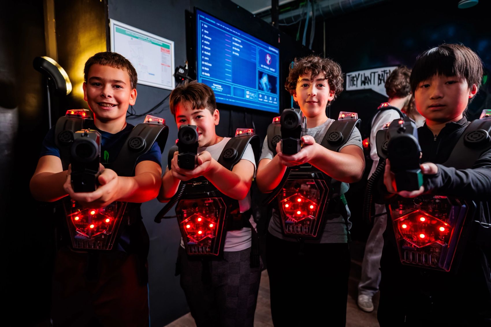 Groep kinderen met rood verlichte lasergamevesten richt pistolen op de camera bij Timestamp Arnhem, gemaakt door Bold Productions