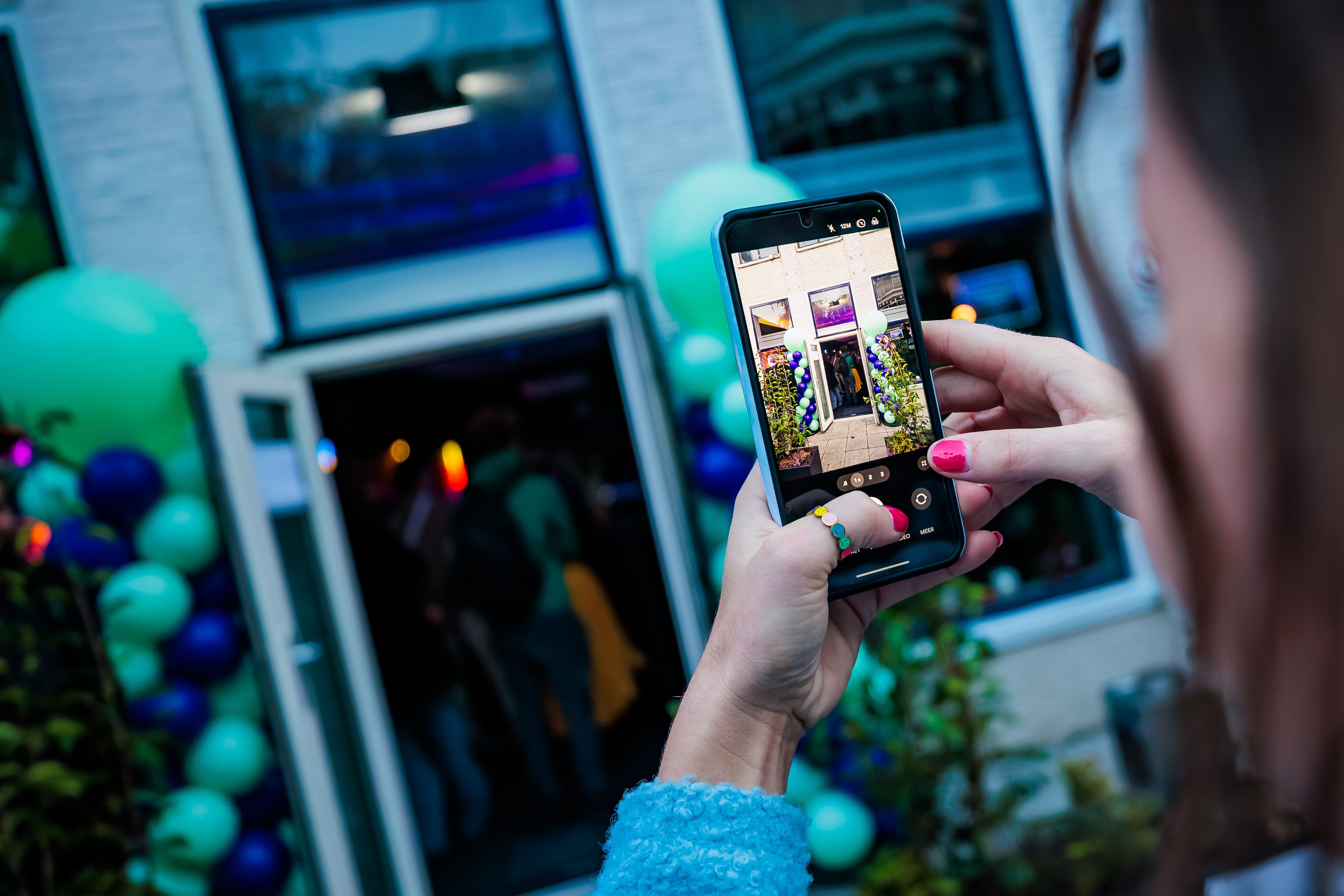 Gast fotografeert de ingang van Timestamp Arnhem met zijn telefoon.