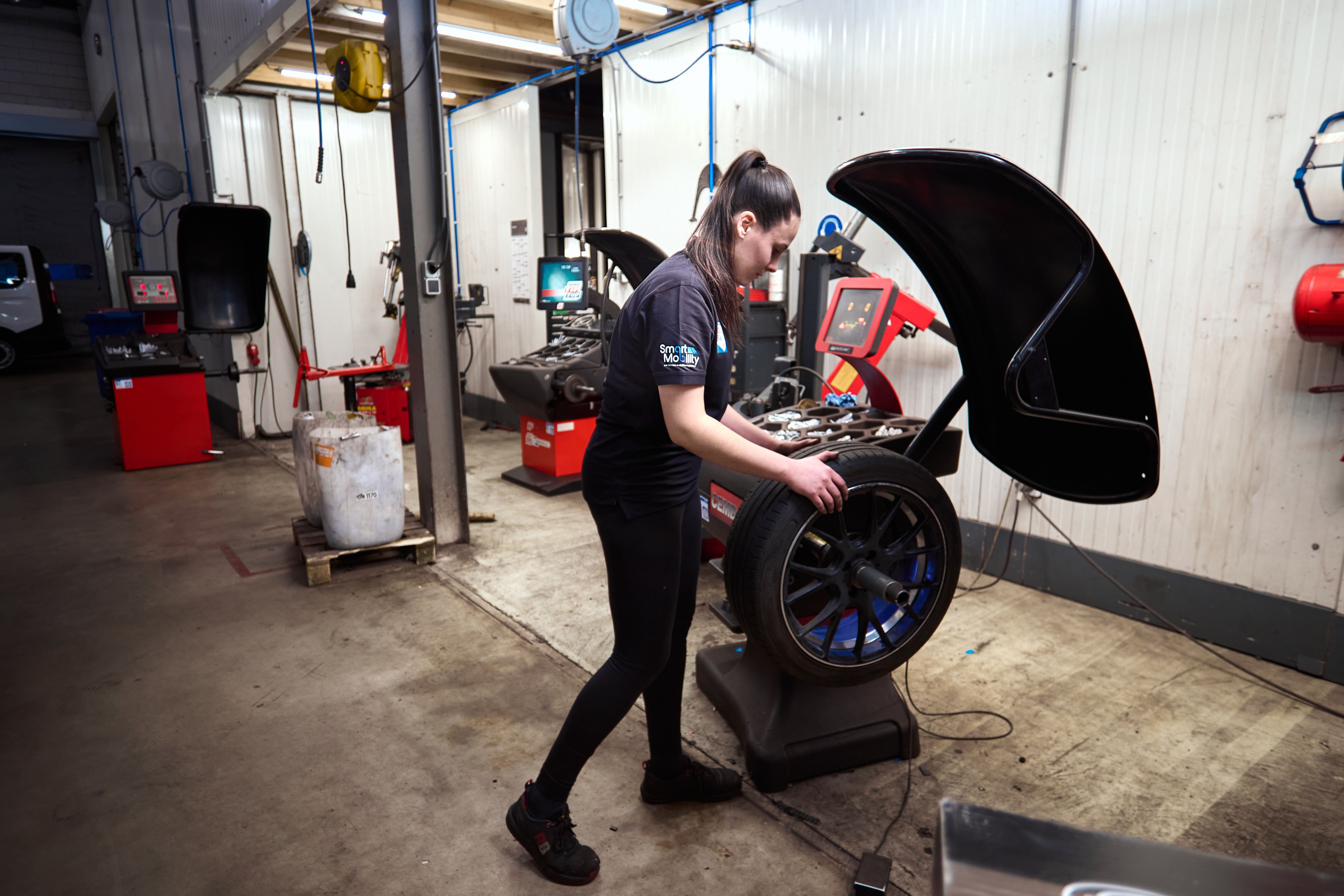 Monteur werkt aan een wiel op de bandenwisselaar in de werkplaats van Auto Vreman.