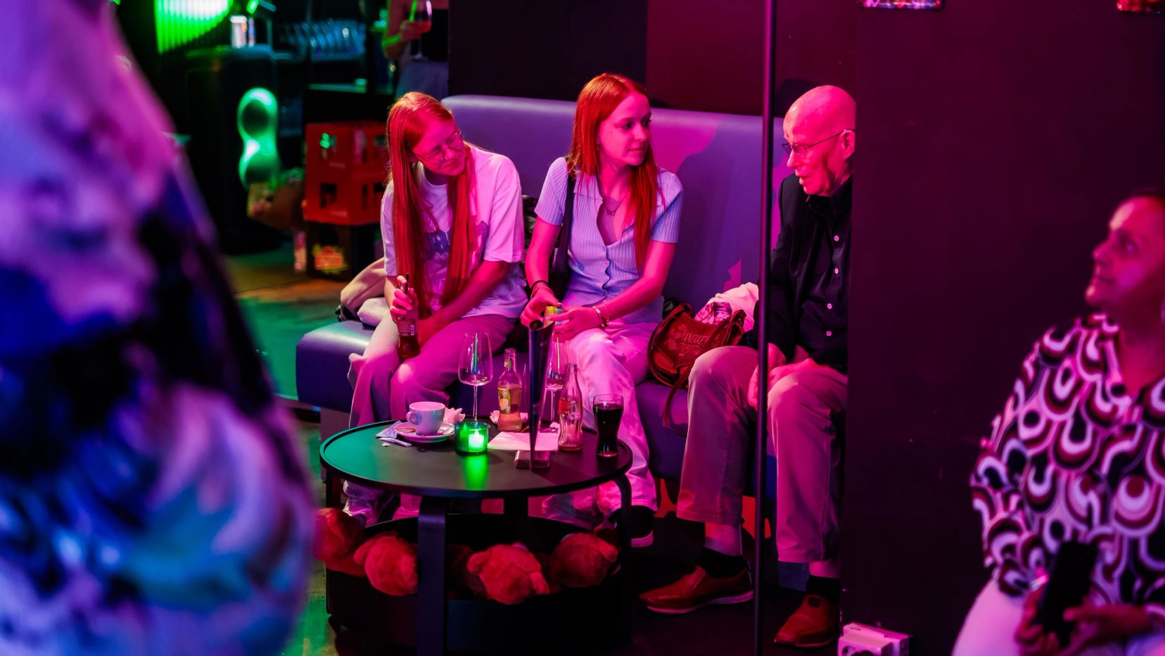 Gasten zitten in een loungehoek met paars licht bij Timestamp Arnhem.