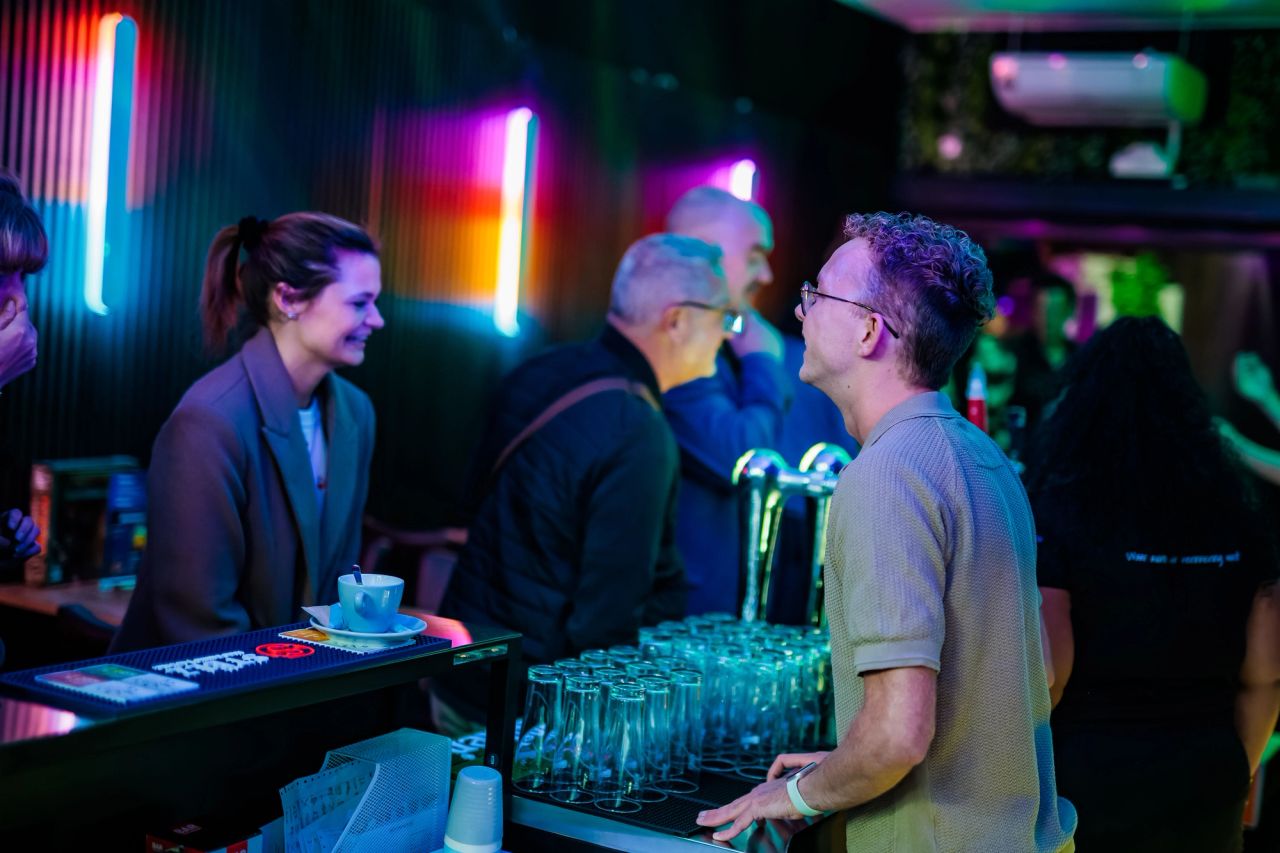 Medewerkers achter de bar met neonlicht bij Timestamp Arnhem.