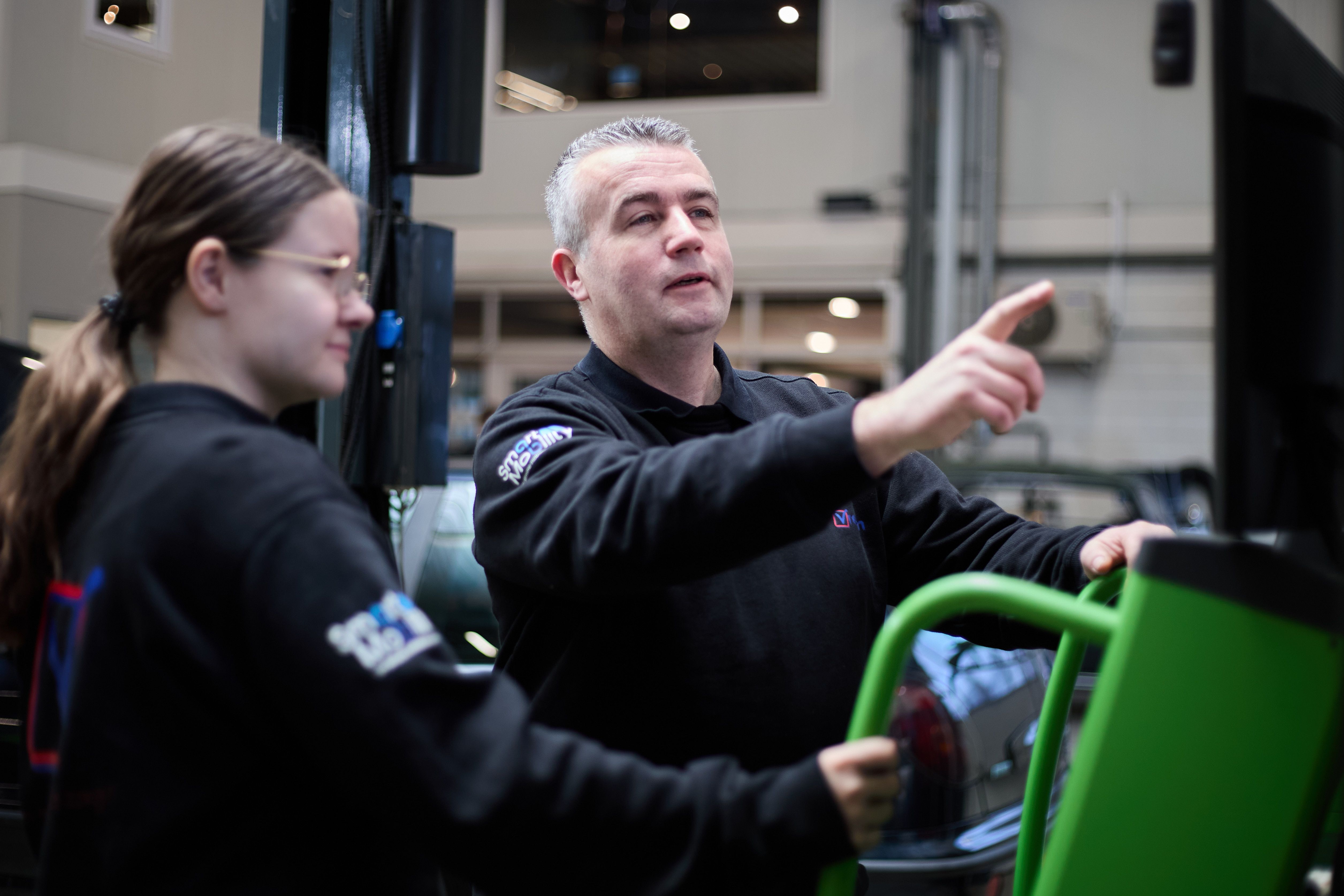 Twee monteurs werken samen aan een auto bij Auto Vreman.