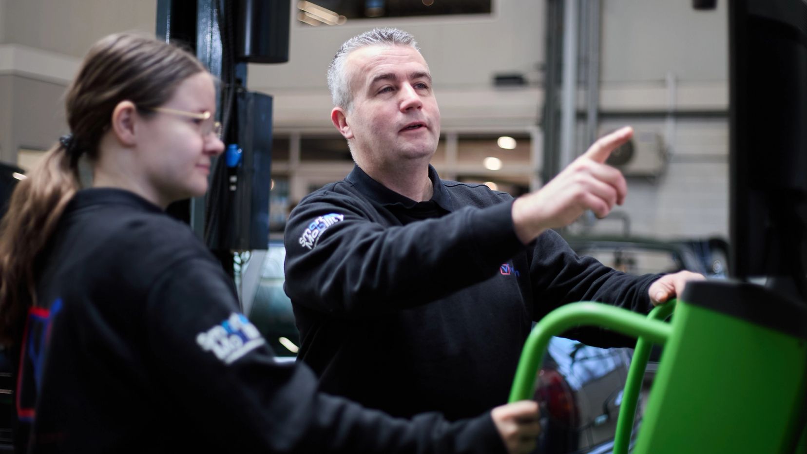 Twee monteurs werken samen aan een auto bij Auto Vreman.
