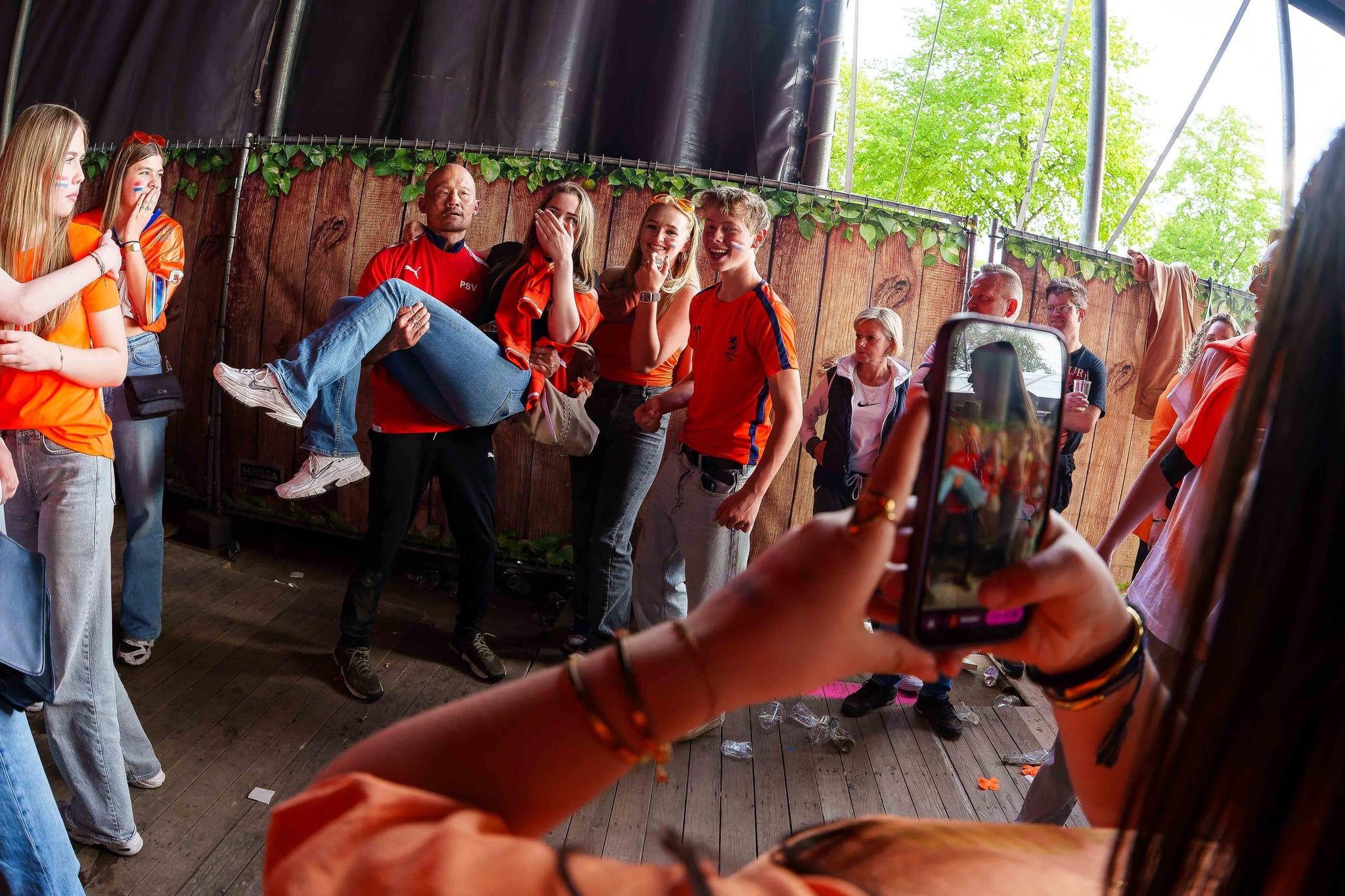 Festivalgangers aan het hekwerk bij het podium, een van hen filmt met een telefoon, gemaakt door Bold Productions