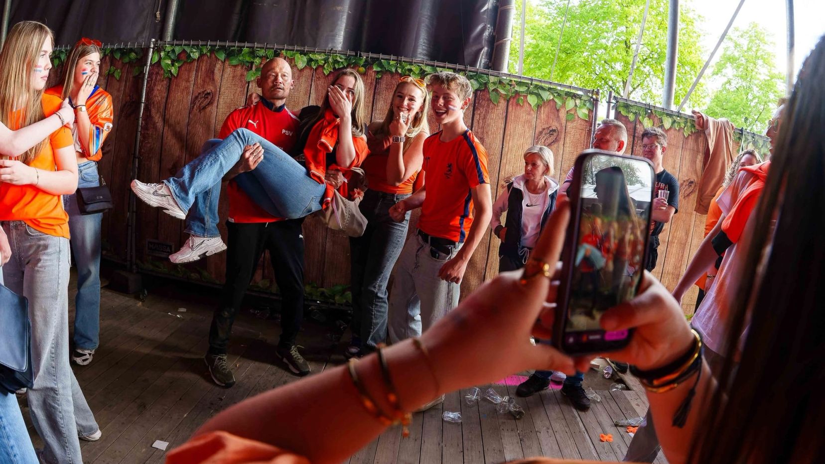 Festivalgangers aan het hekwerk bij het podium, een van hen filmt met een telefoon, gemaakt door Bold Productions