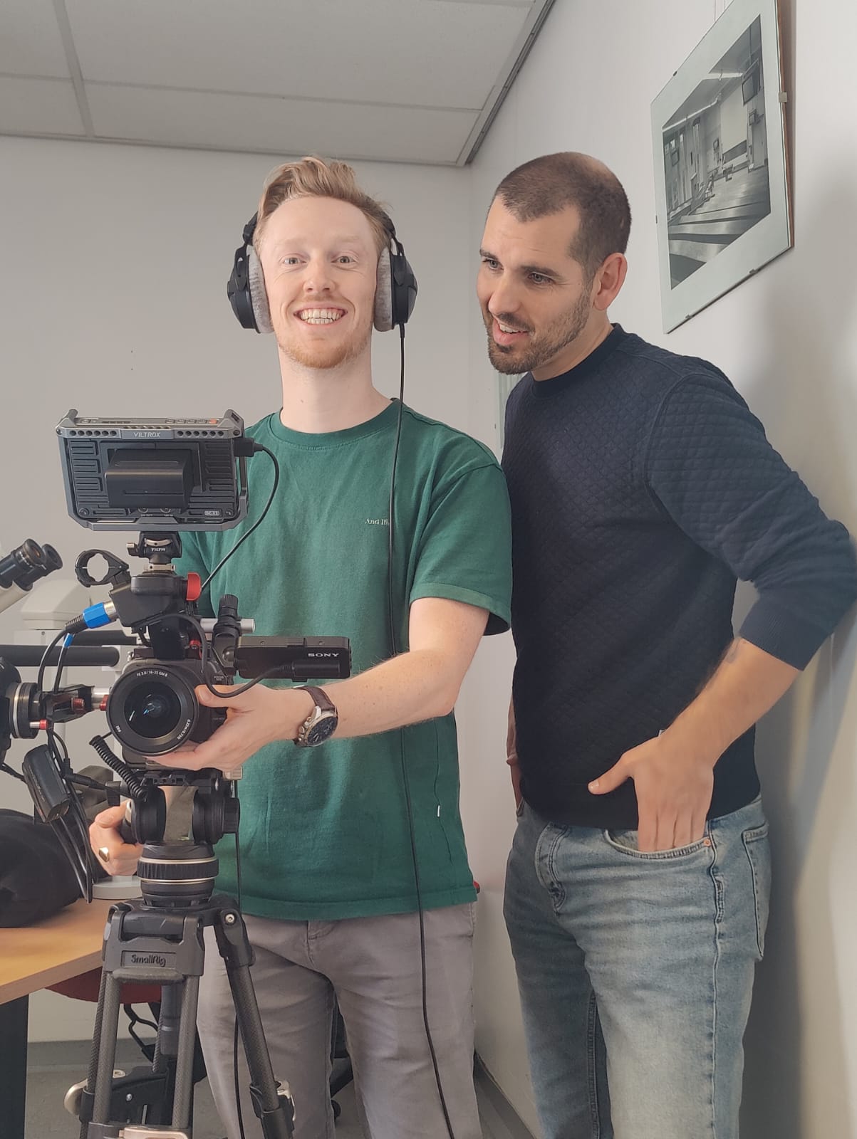 Twee mannen naast een professionele videocamera op statief, een van hen met koptelefoon op, gemaakt door Bold Productions