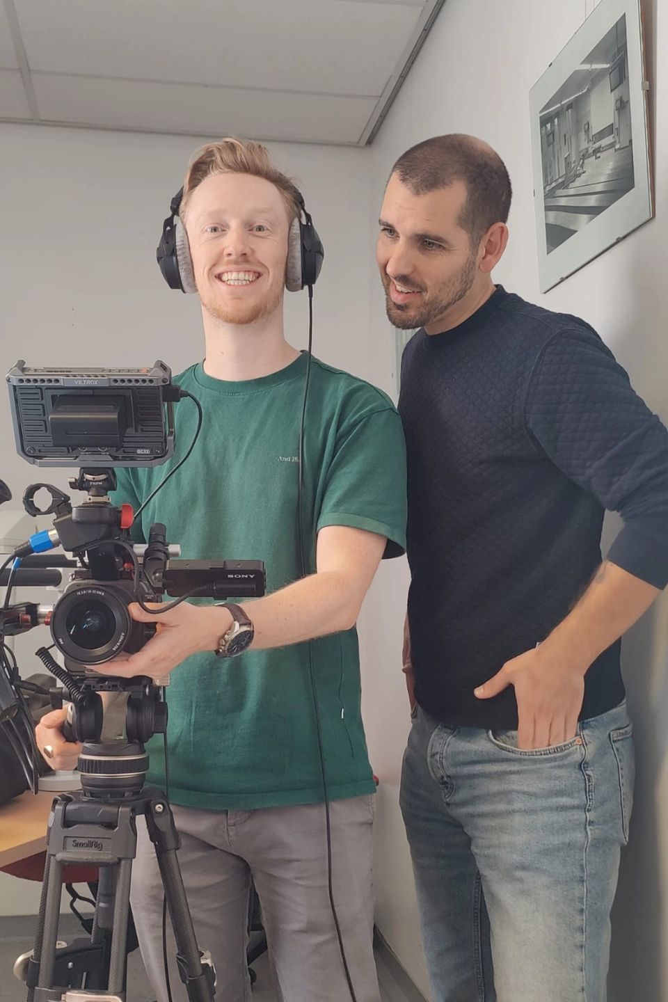 Twee mannen naast een professionele videocamera op statief, een van hen met koptelefoon op, gemaakt door Bold Productions