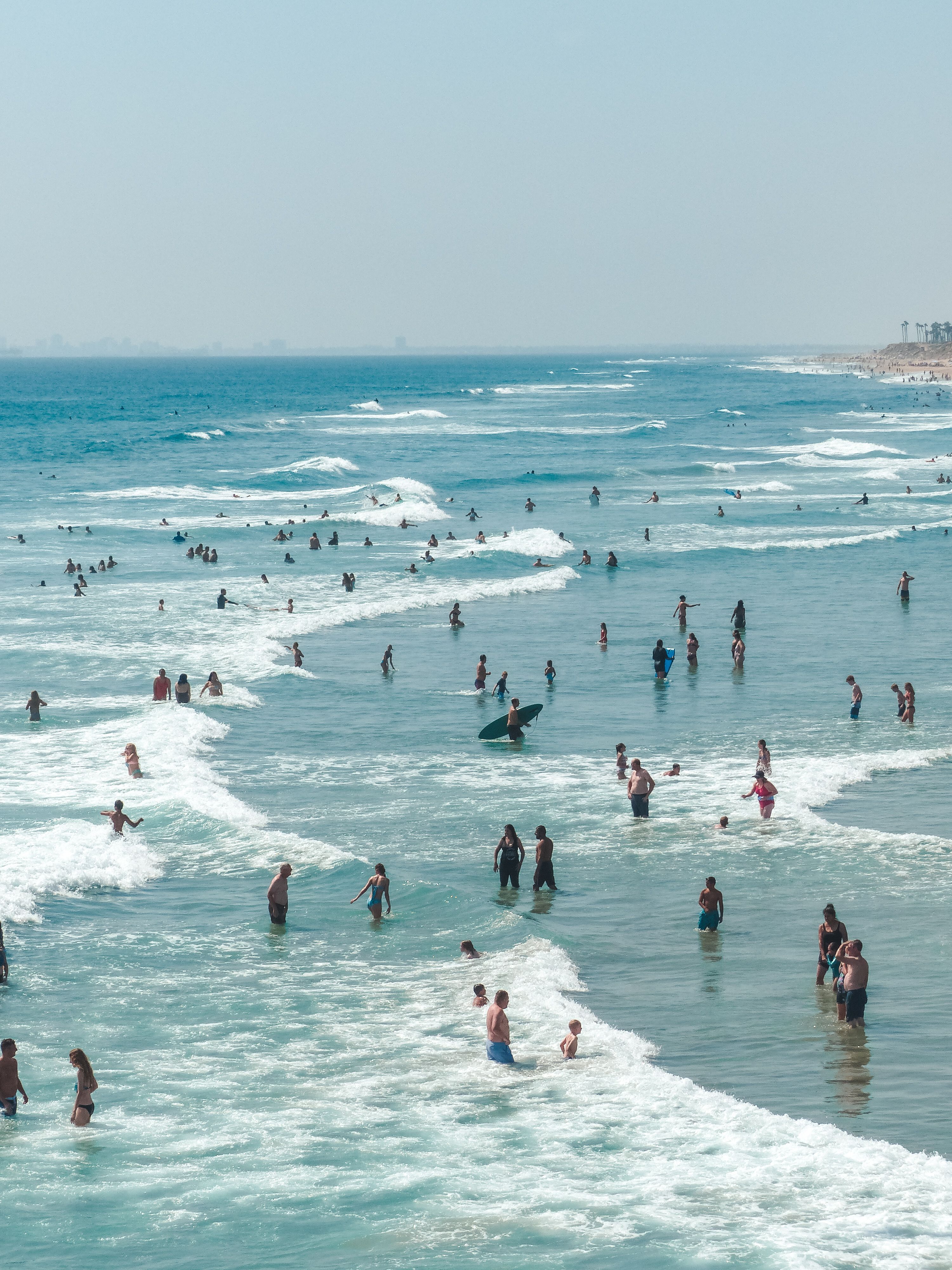 Swimmers and surfers in the sea on a summer day