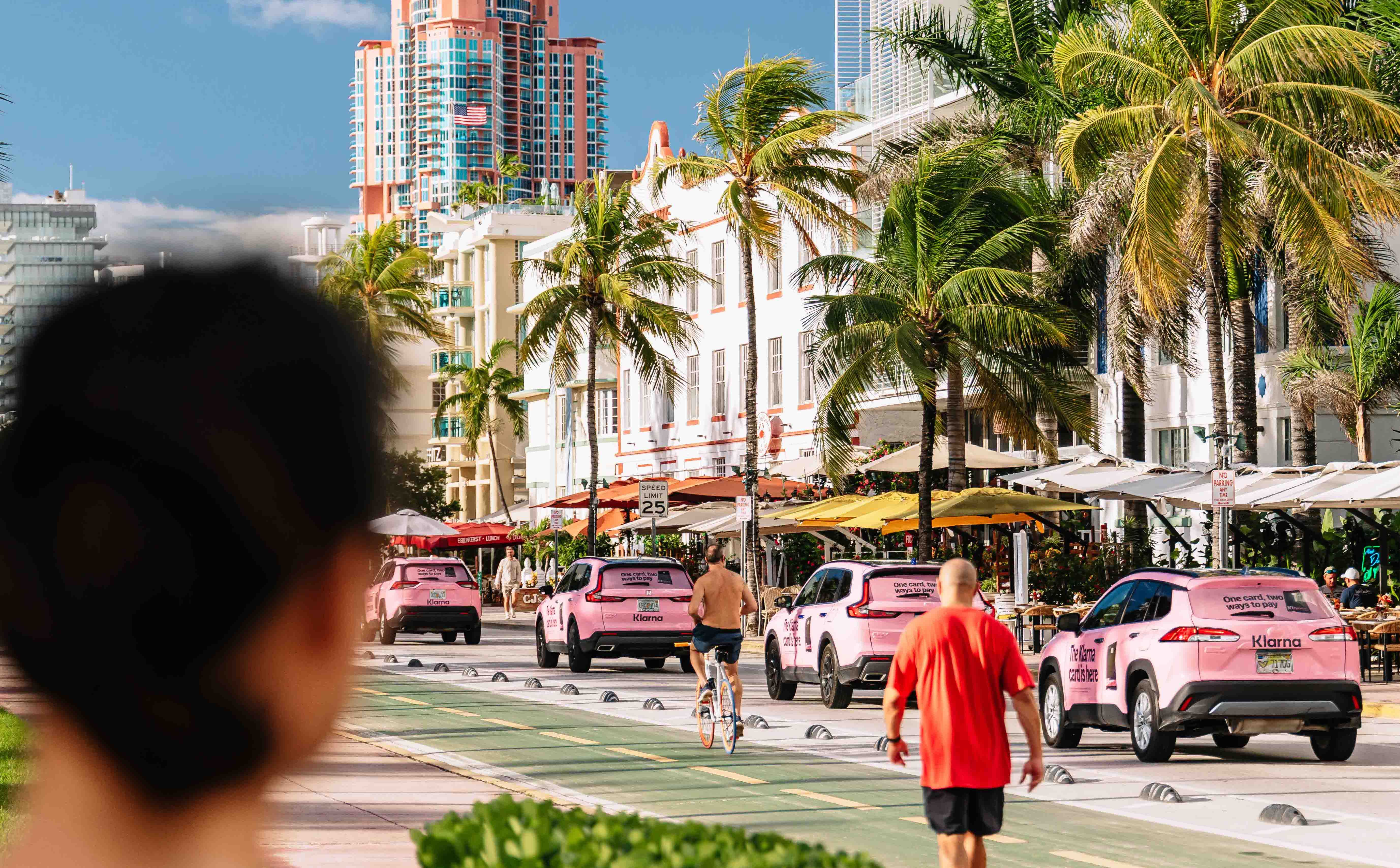 Person in Miami looking at fleet of wrapped pink cars with Klarna branding