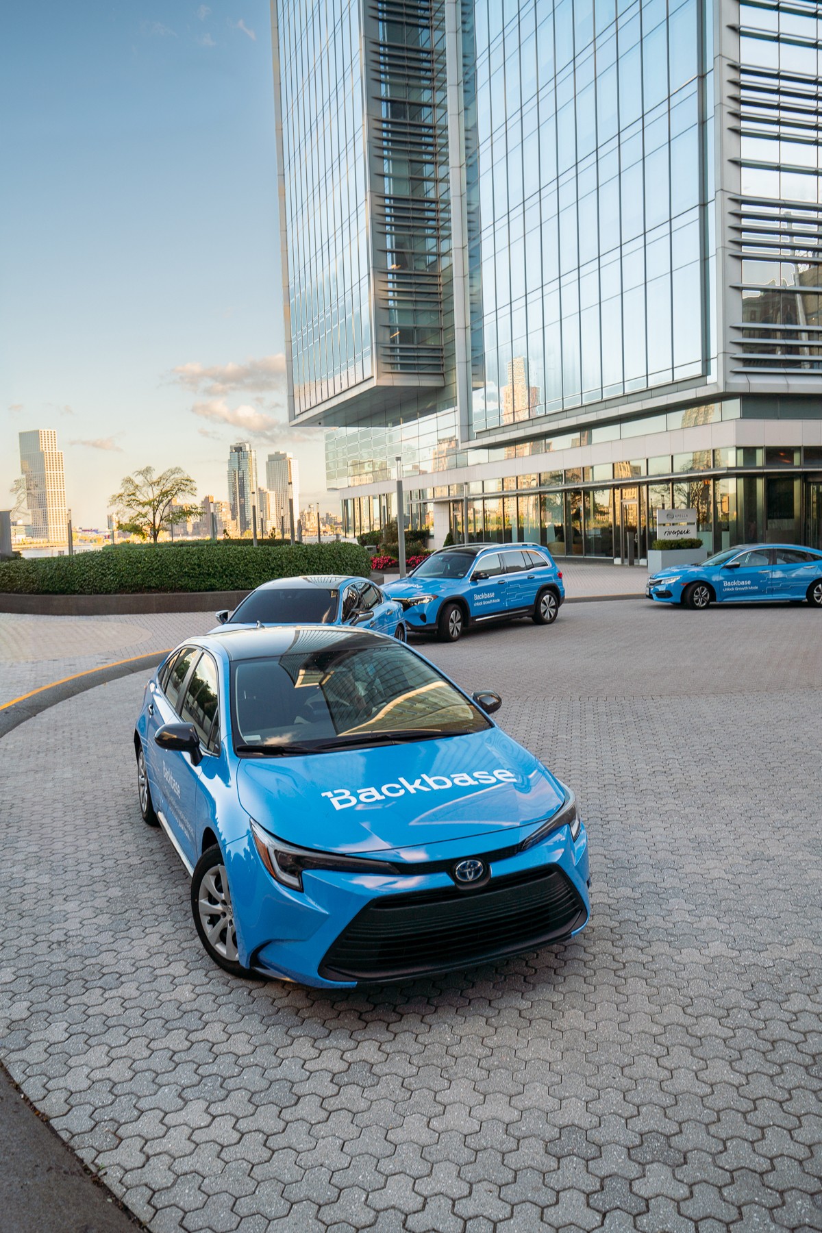 Backbase cars wrapped in blue in swarm formation at event venue entrance