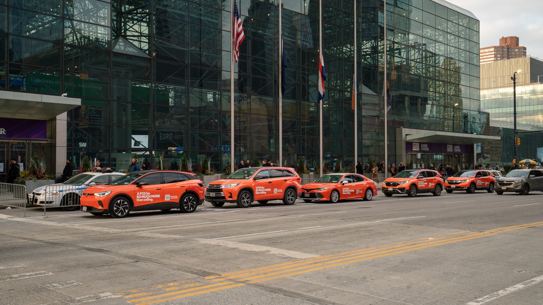 Fleet of orange-wrapped branded vehicles lined up outside the Jacob Javits Convention Center in New York City during NRF retail conference