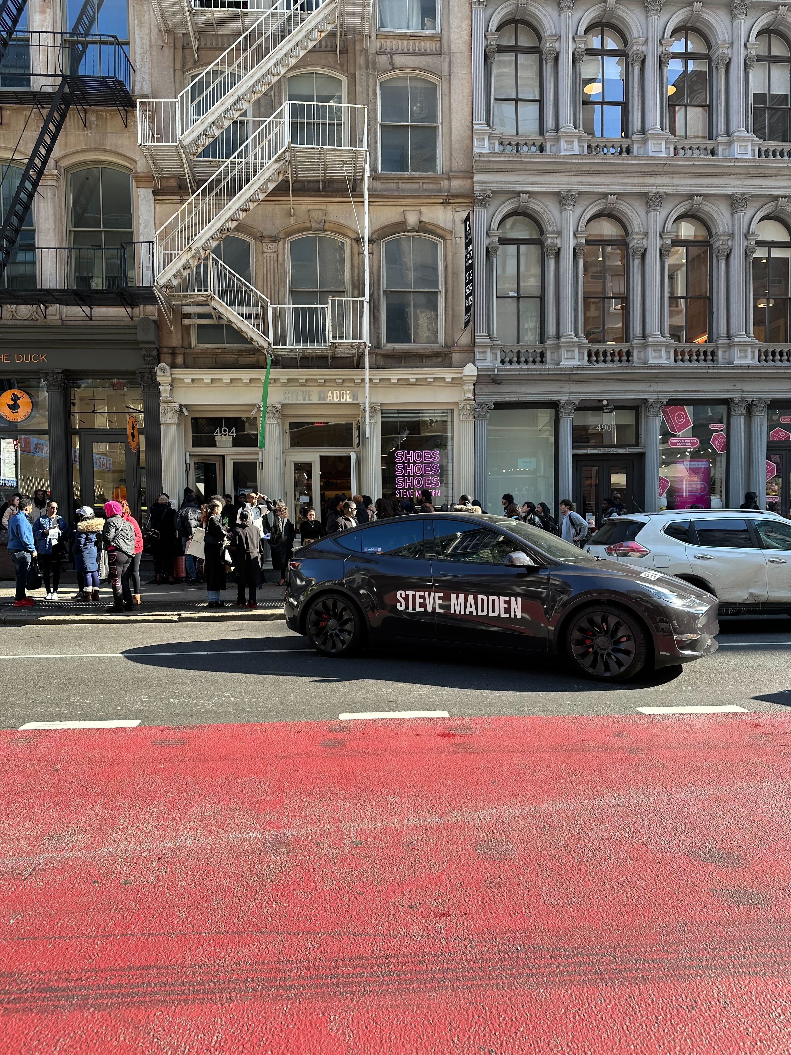 Crowds line up outside of Steve Madden store in SOHO where free product giveaways where happening during NWFW from the trunk of the wrapped cars 