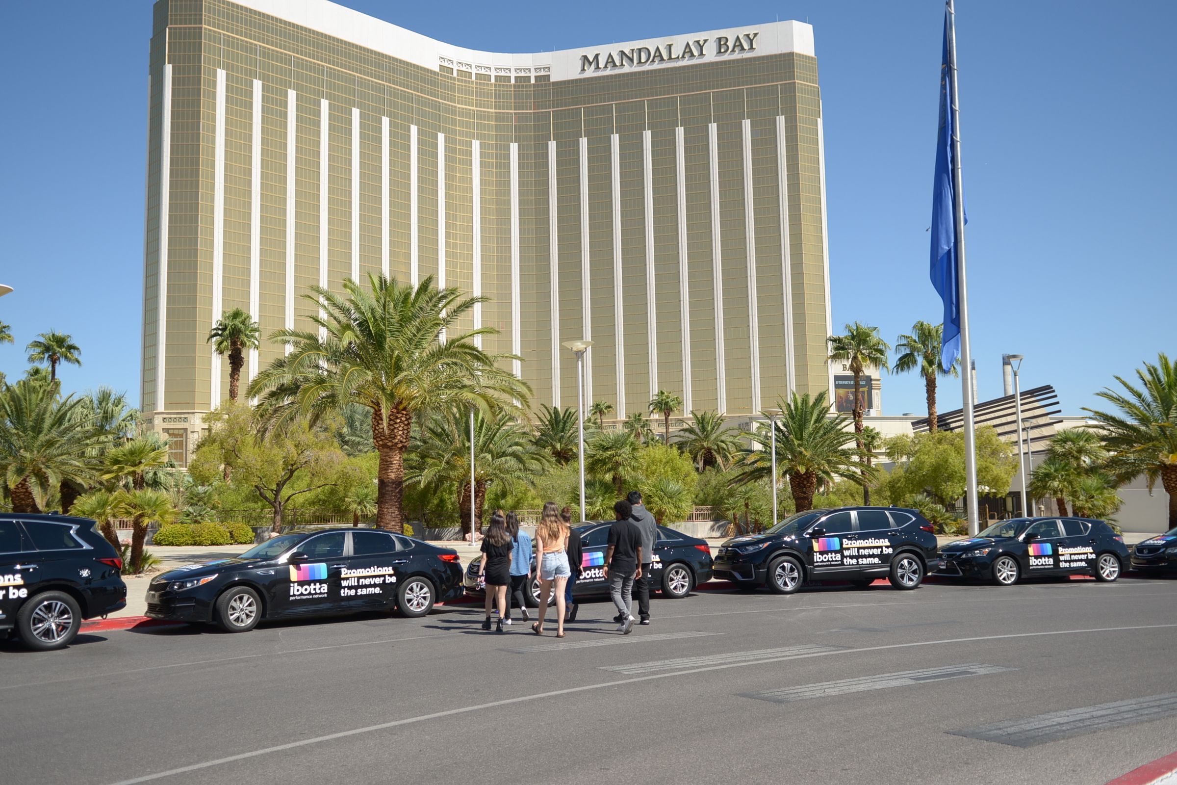 Fleet of Ibotta-branded black vehicles parked outside Mandalay Bay resort in Las Vegas during a brand activation campaign