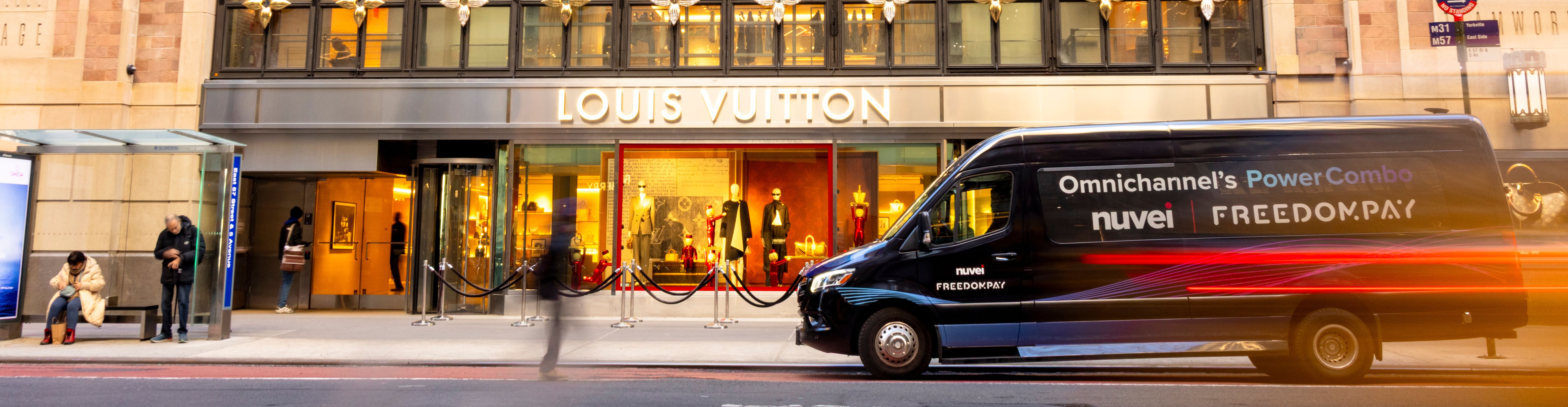 Nuvei and FreedomPay branded black van parked in front of a Louis Vuitton store in New York City.
