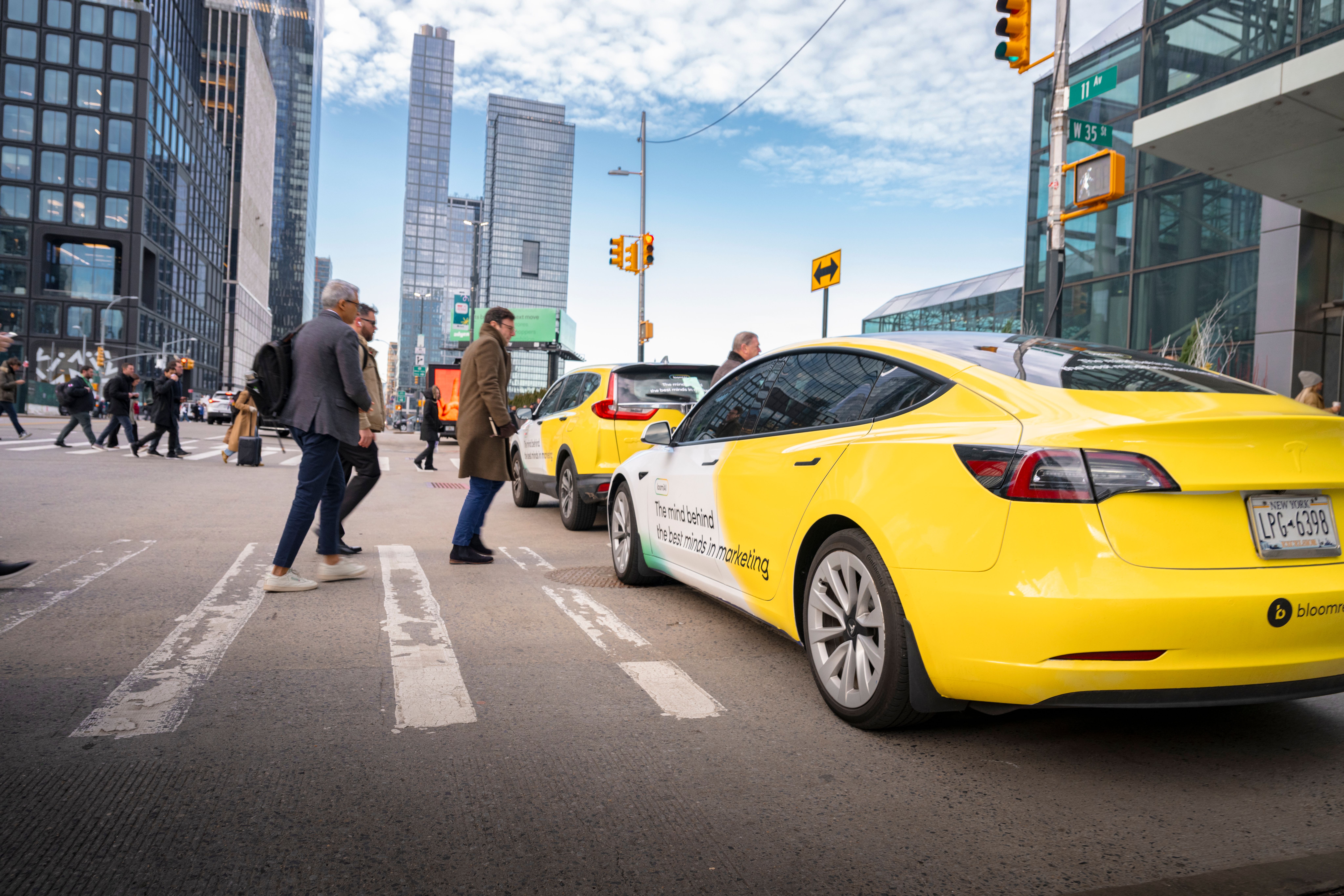 Wrapped vehicles for BloomReach are driving down a city street