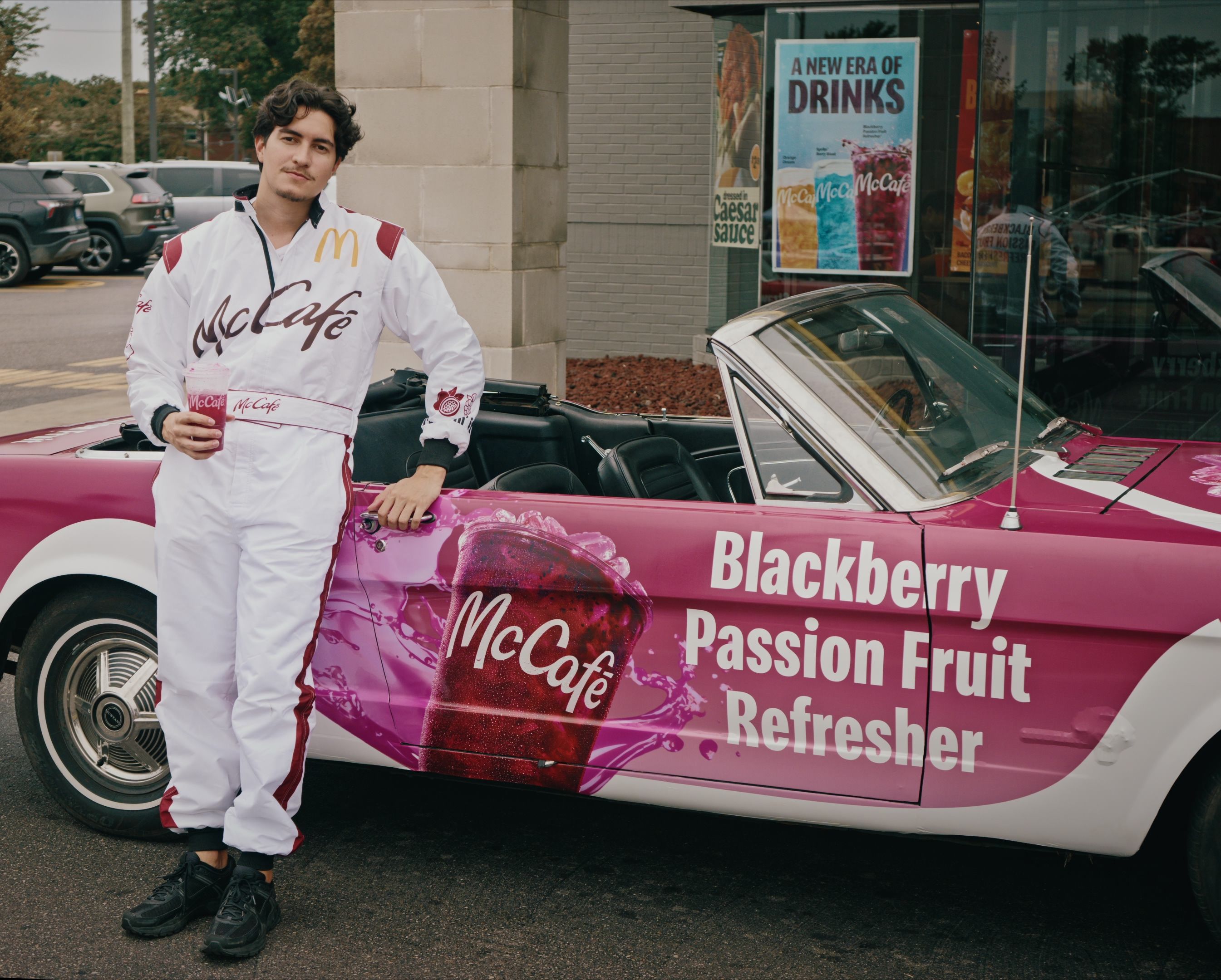 Wrapped vintage Mustang with Mcdonald's McCafe drink branding and driver standing in front 