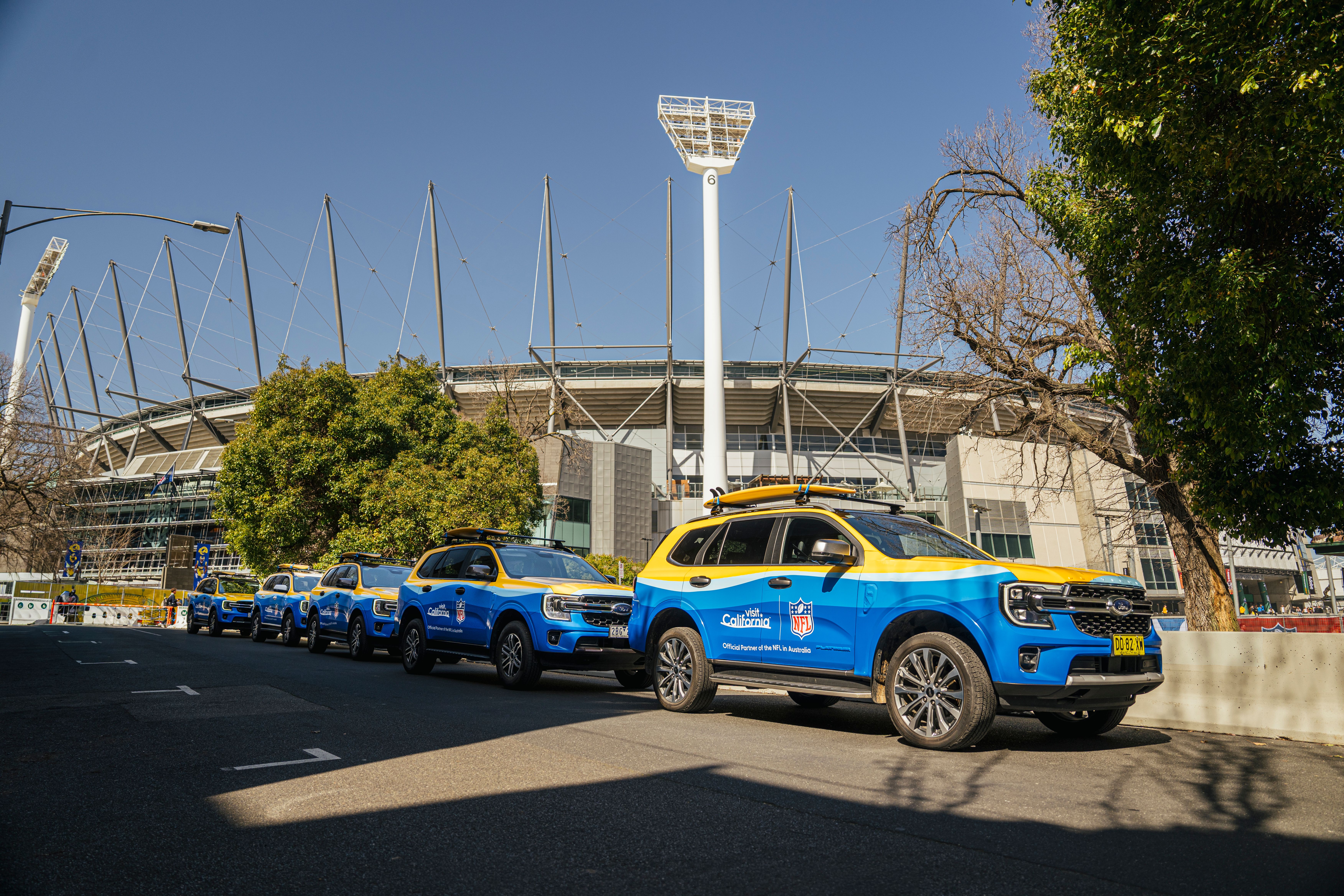 Fleet of wrapped cars for Visit California x NFL in front of Melbourne Australia stadium 