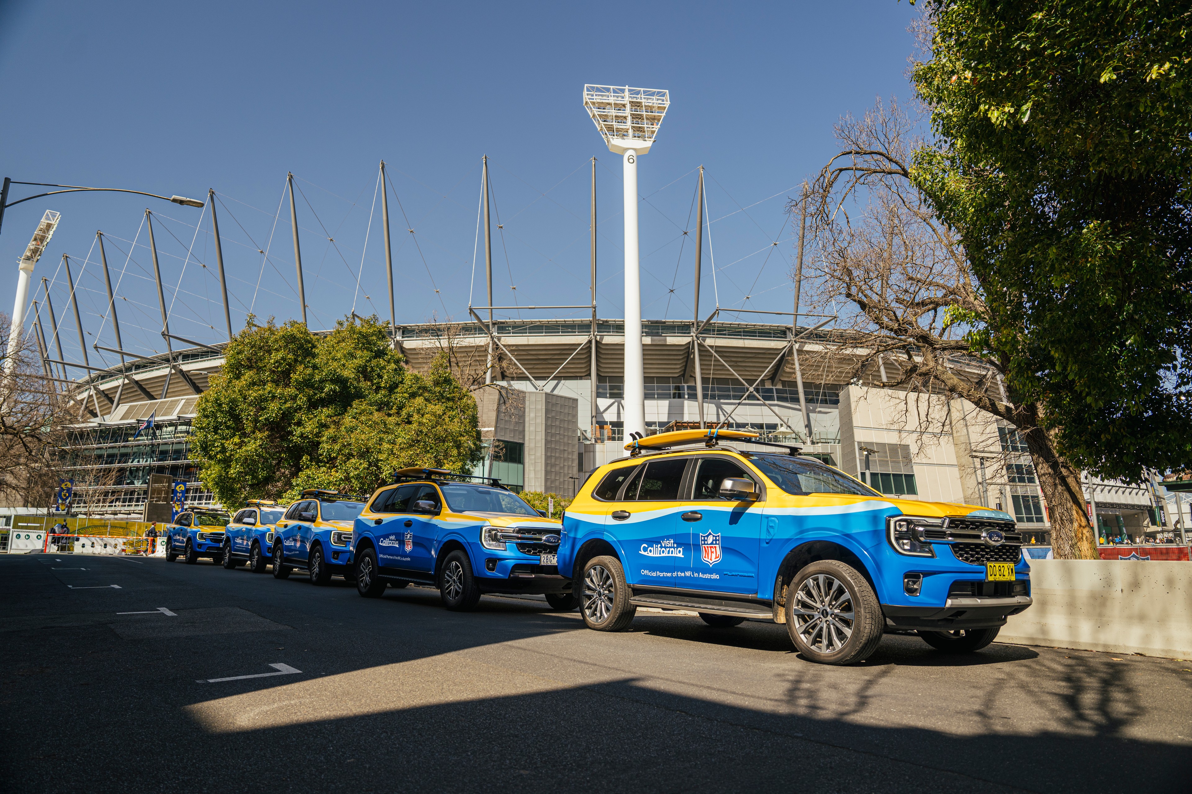 Fleet of wrapped cars for Visit California x NFL in front of Melbourne Australia stadium