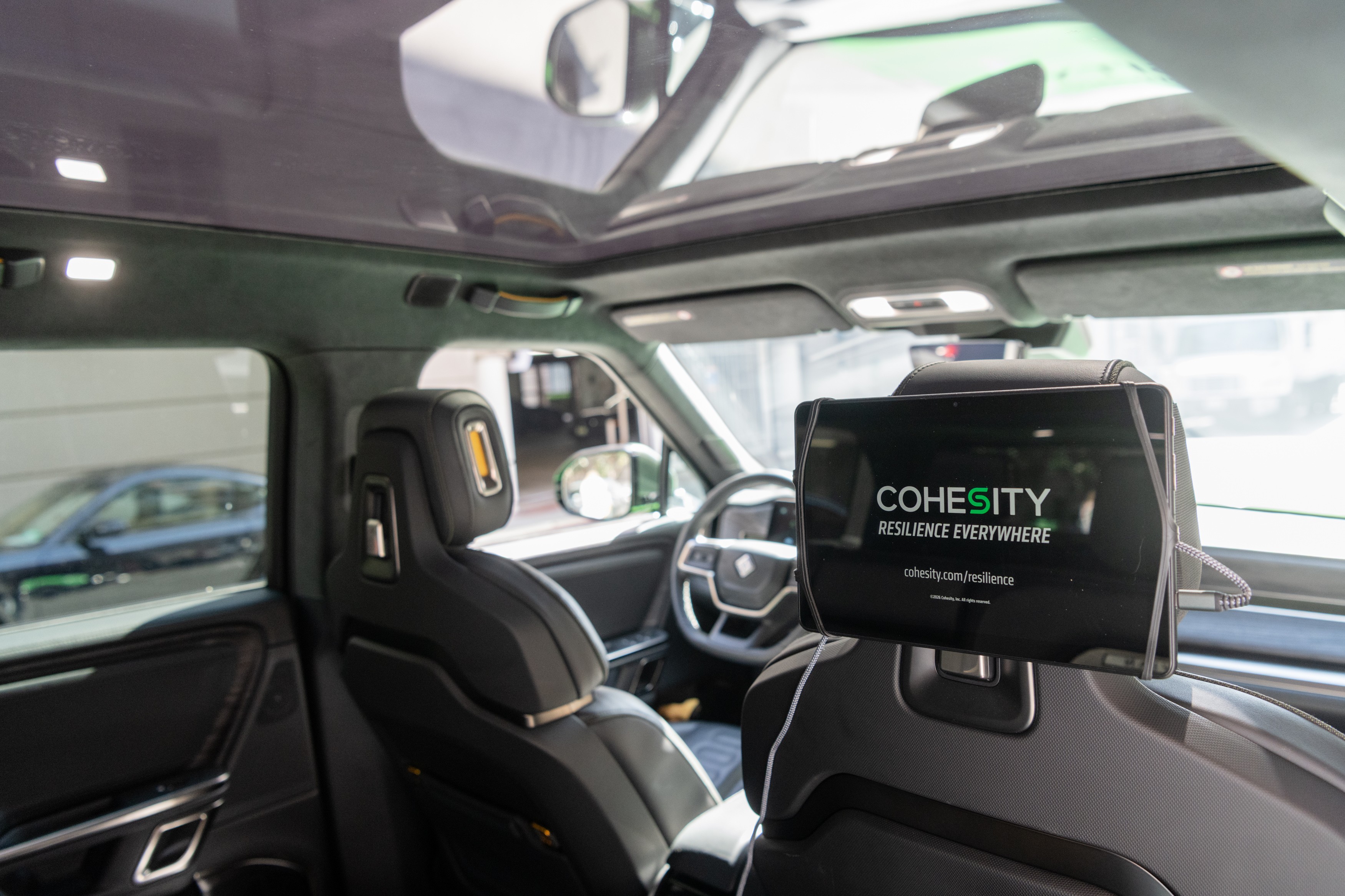 Interior of wrapped car showing headrest tablet with Cohesity branding