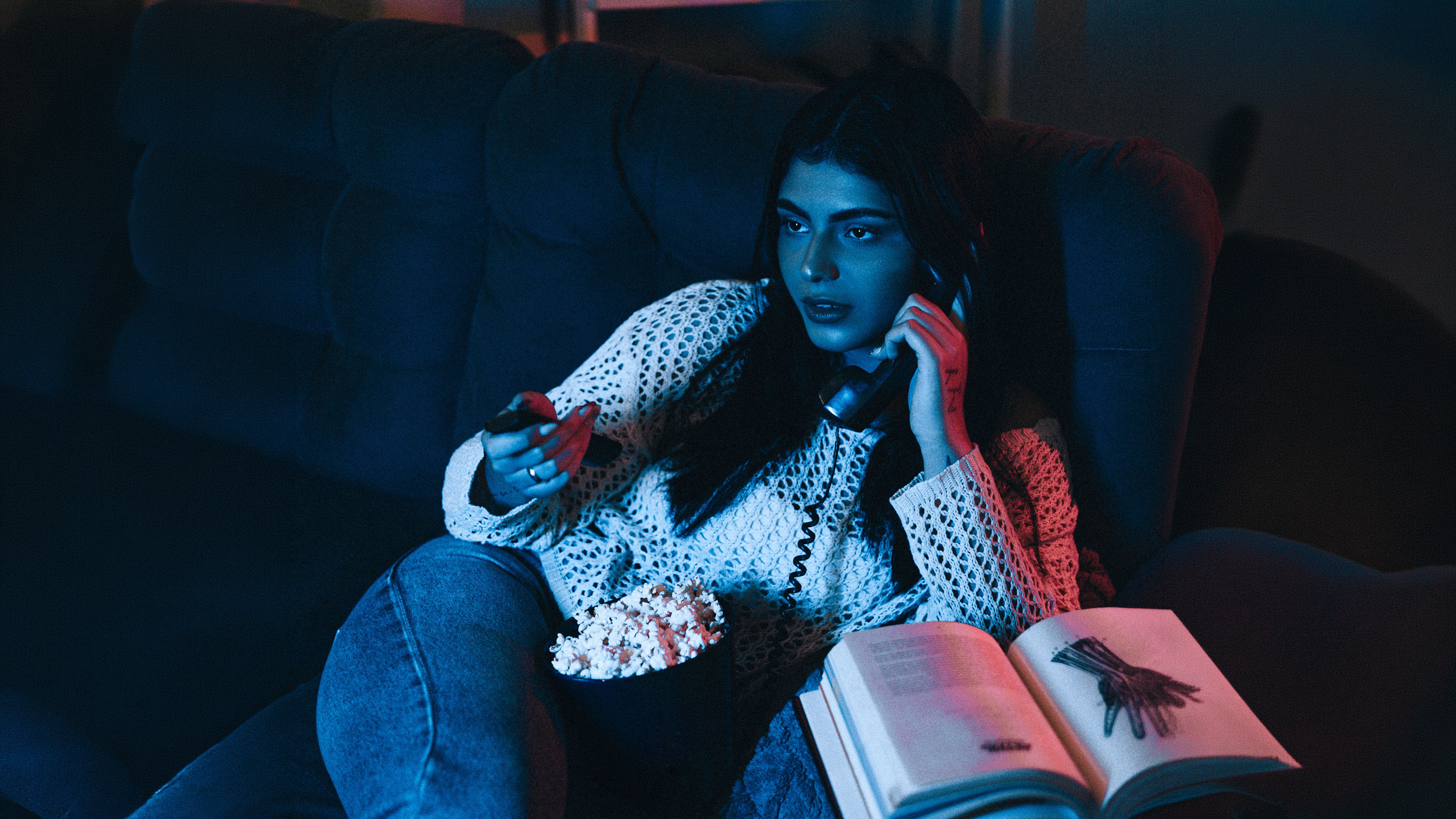 A reviewer at home late in the evening, watching a film.