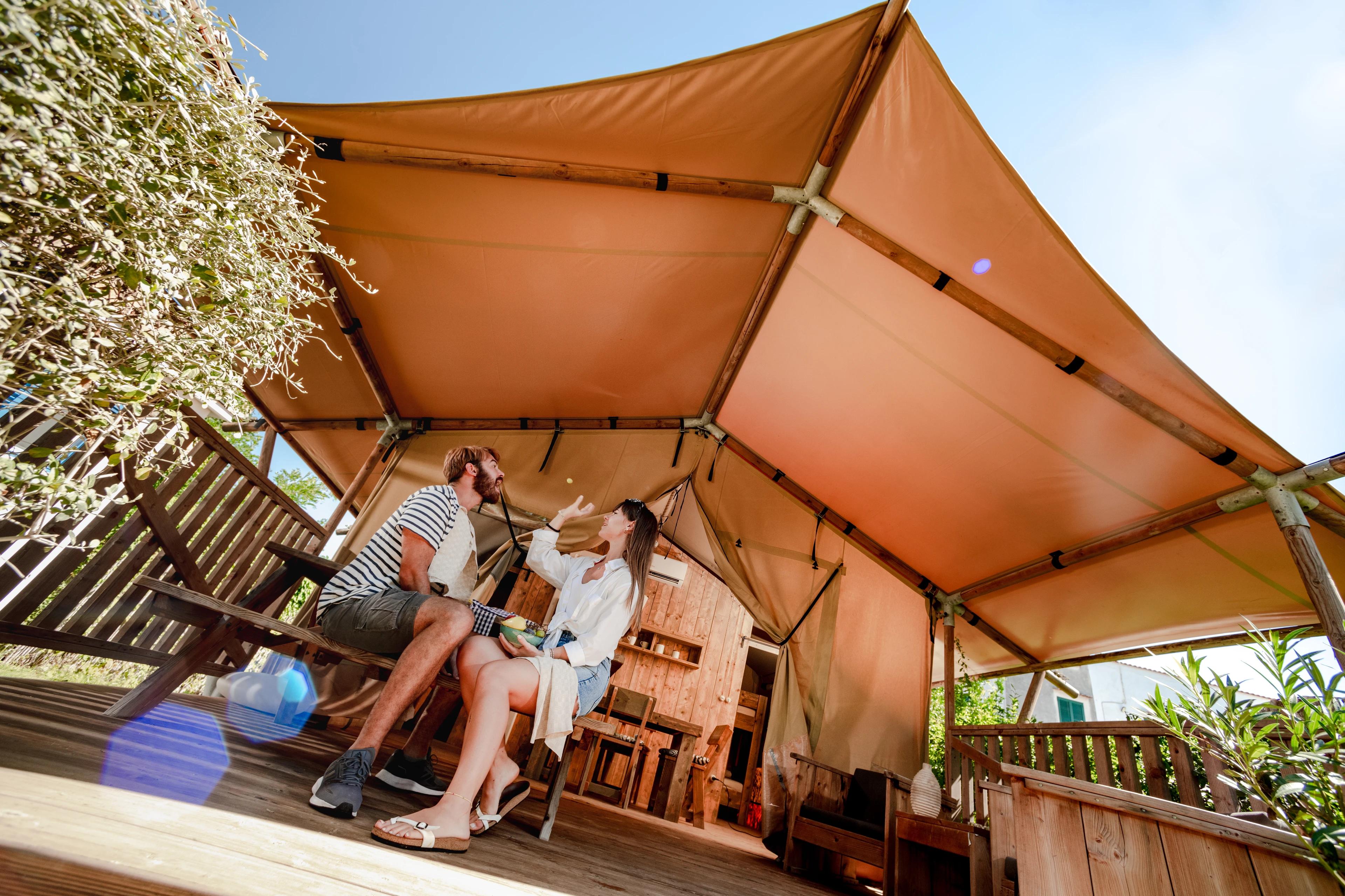 Young couple have fun under a glamping tent