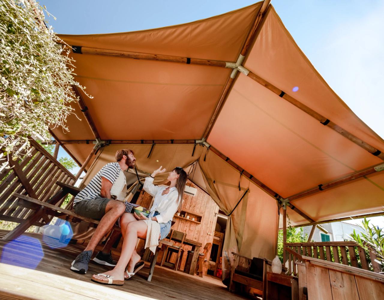 Young couple have fun under a glamping tent