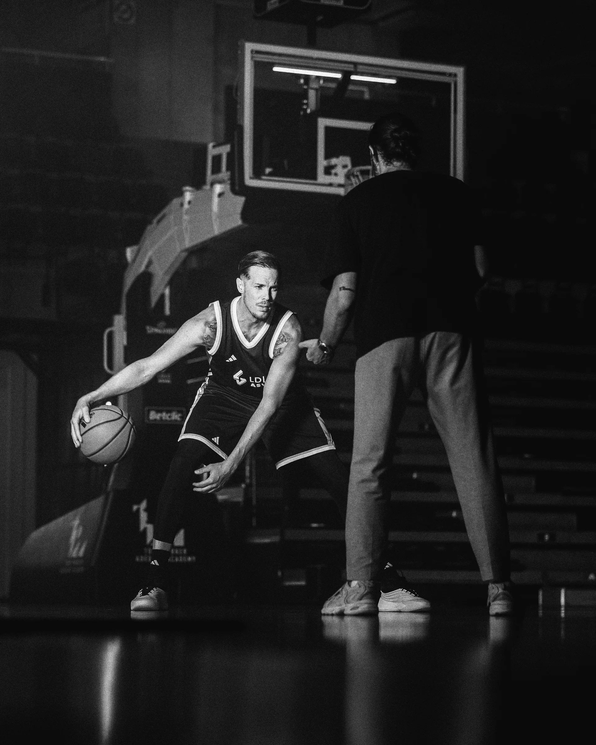Un joueur prépare un dribble face à un membre de l’équipe sur le terrain.