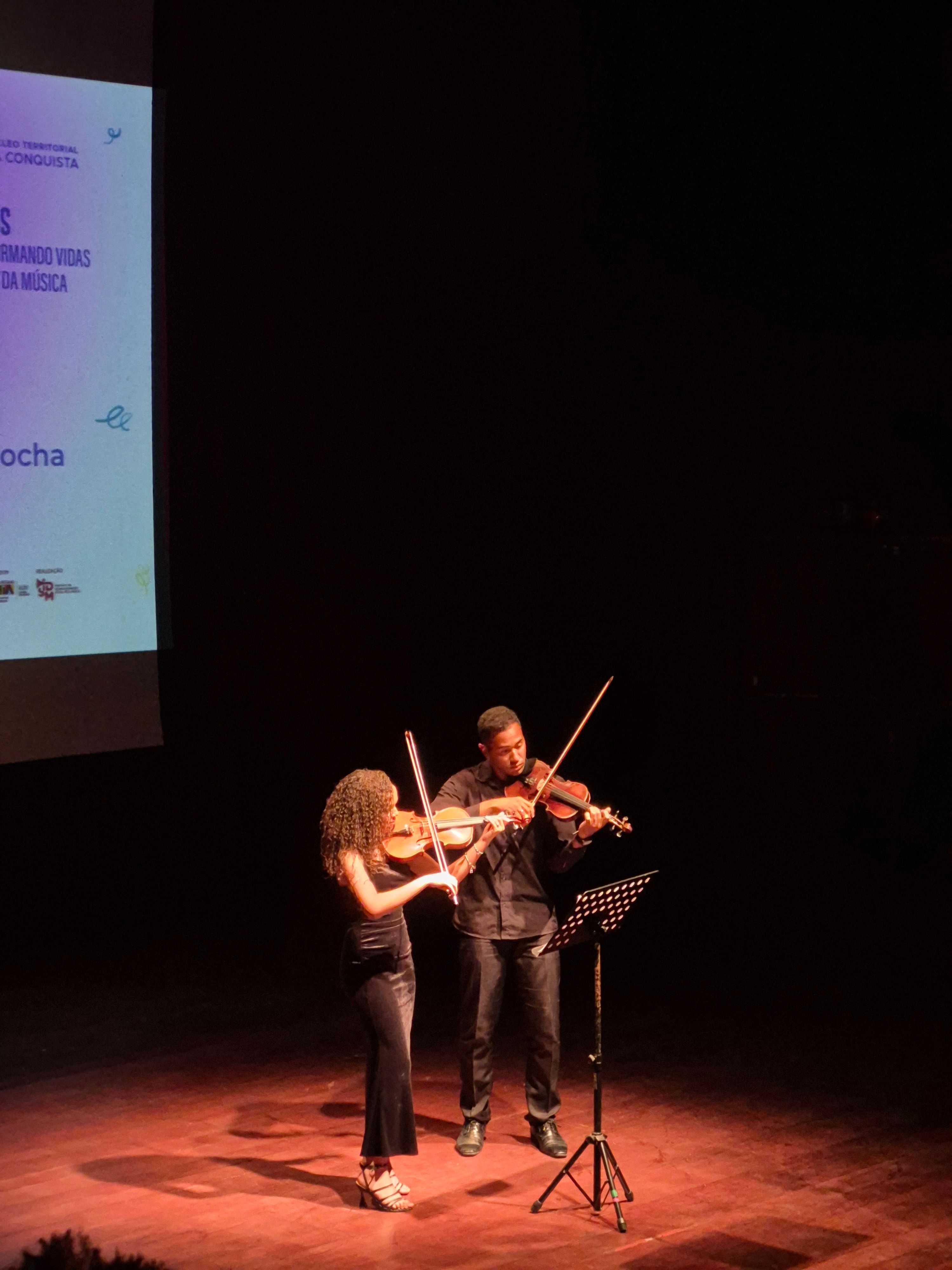 2 pessoas tocando violino