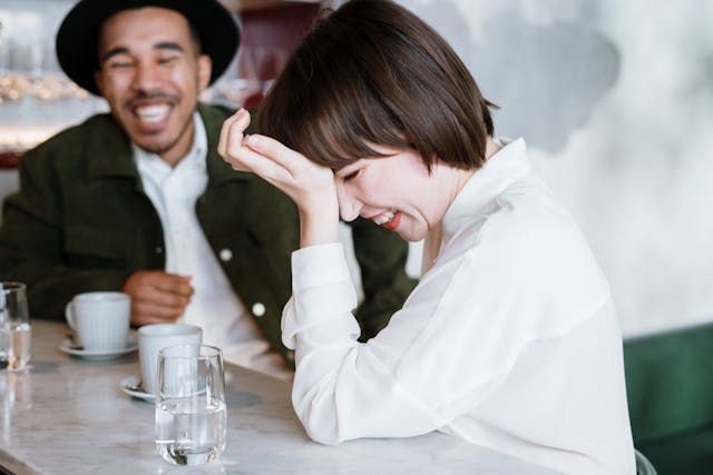 Woman and man laughing - first date questionsSource Pexels | Photo by cottonbro studio