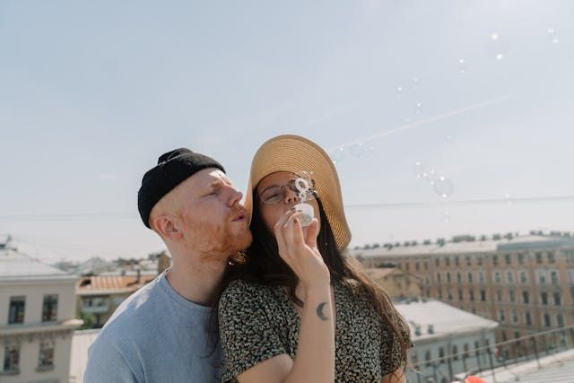 Man and woman smiling while holding hands - first date ideaSource Pexels | Photo by cottonbro studio