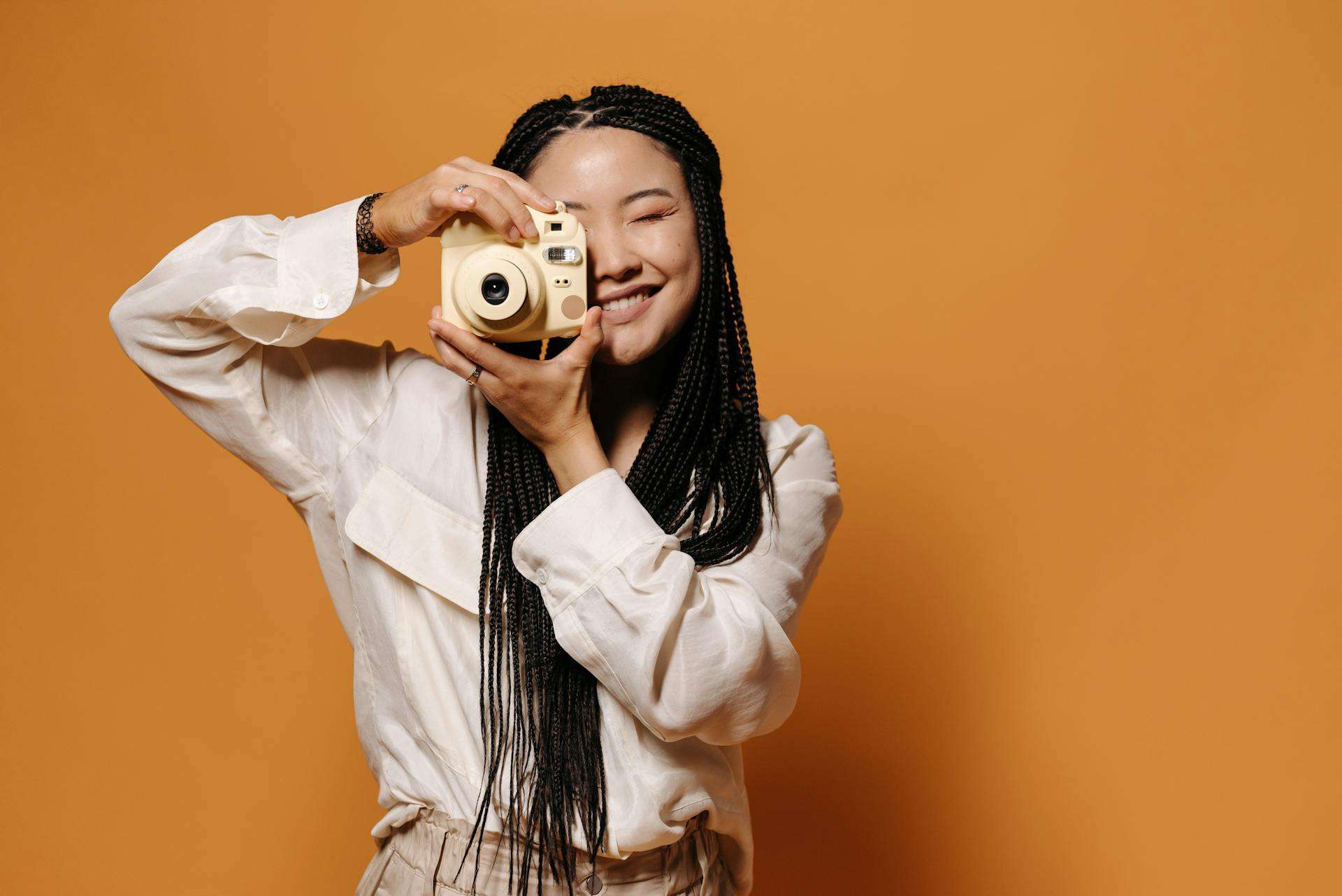 A woman holding a camera taking a perfect online dating profile picture