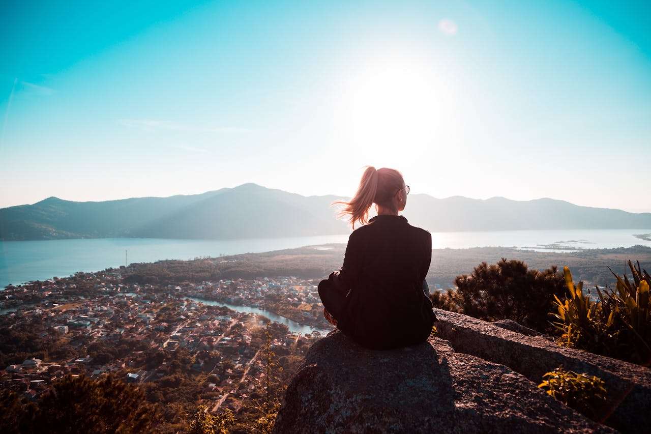 Woman sitting at the edge of mountain