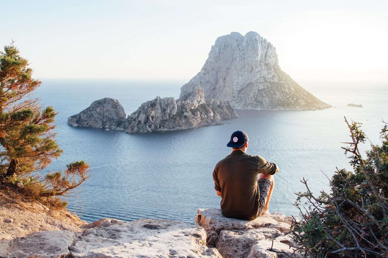 Picture of man sitting on the cliff watchting the sunset