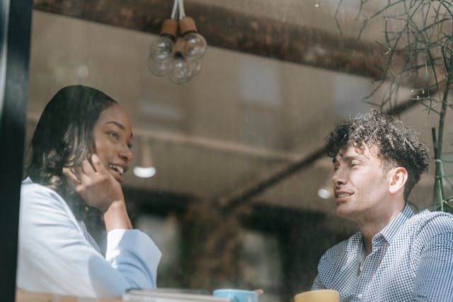 Man and woman talking near the window - first date questionsSource Pexels | Photo by Mike Jones