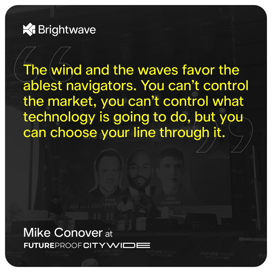 A digital graphic features a quote in bold yellow text on a dark, semi-transparent background. The quote reads: "The wind and the waves favor the ablest navigators. You can’t control the market, you can’t control what technology is going to do, but you can choose your line through it." Below the quote, in white text, it attributes the statement to Mike Conover at FUTUREPROOF CITYWIDE. The background shows a blurred image of a panel discussion with three speakers’ faces displayed on a large screen. The image includes the Brightwave logo in the upper left corner.