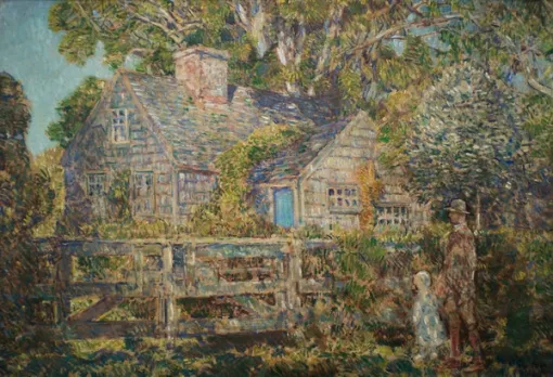 A wooden house situated in a lush garden with tall trees with a fence in the foreground