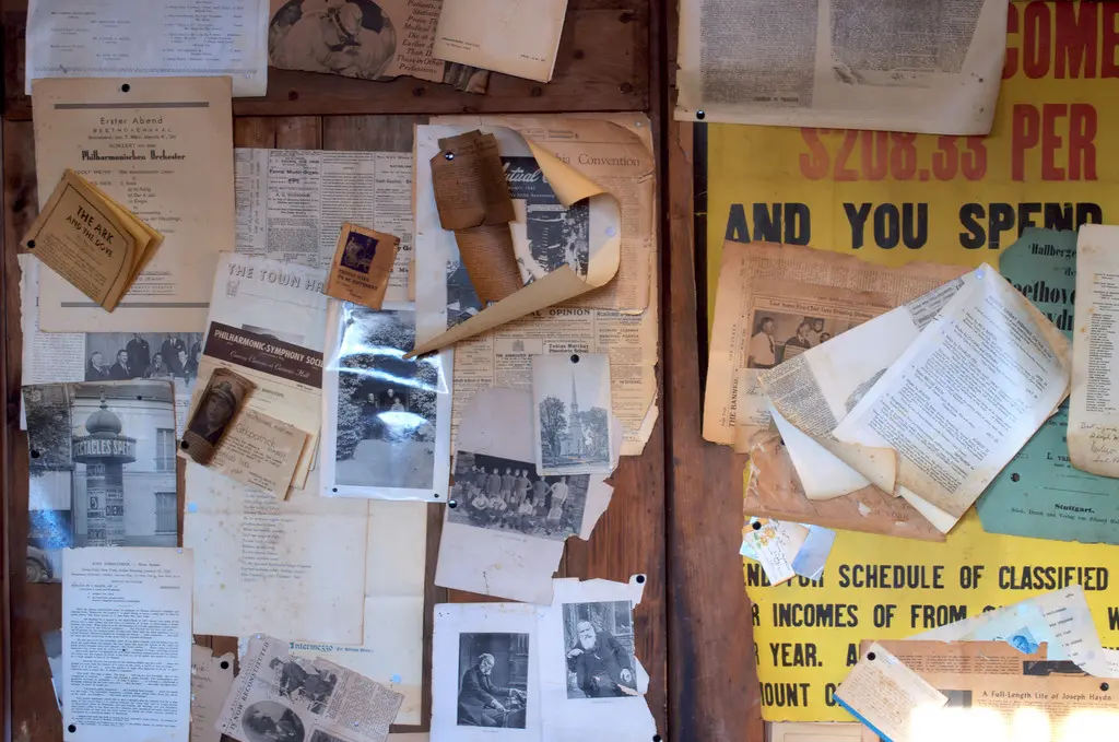 Clippings and photographs pinned to wooden doors.