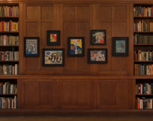 Framed collages in wood-paneled library