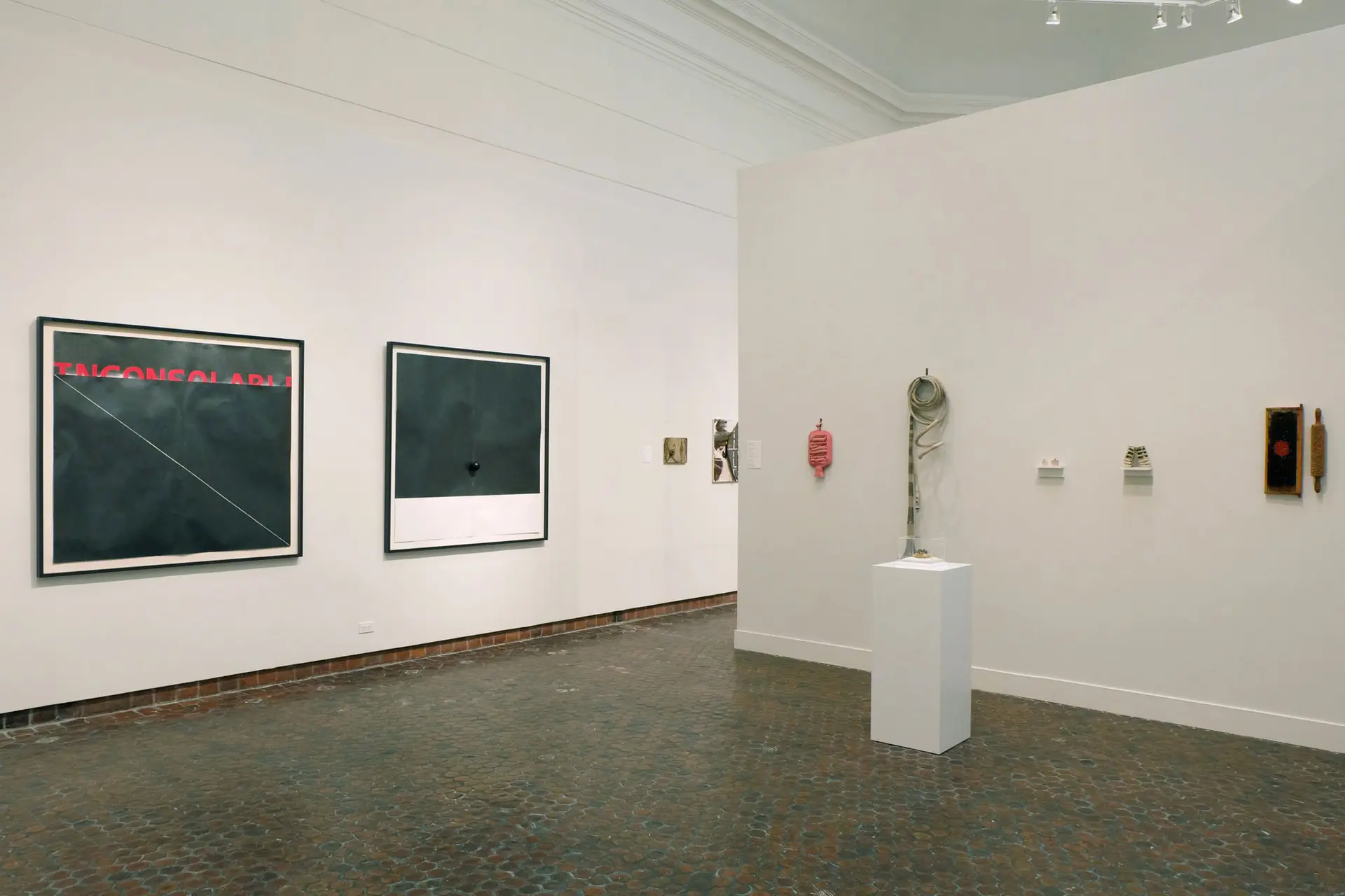 Gallery with artworks installed on the walls and floor.