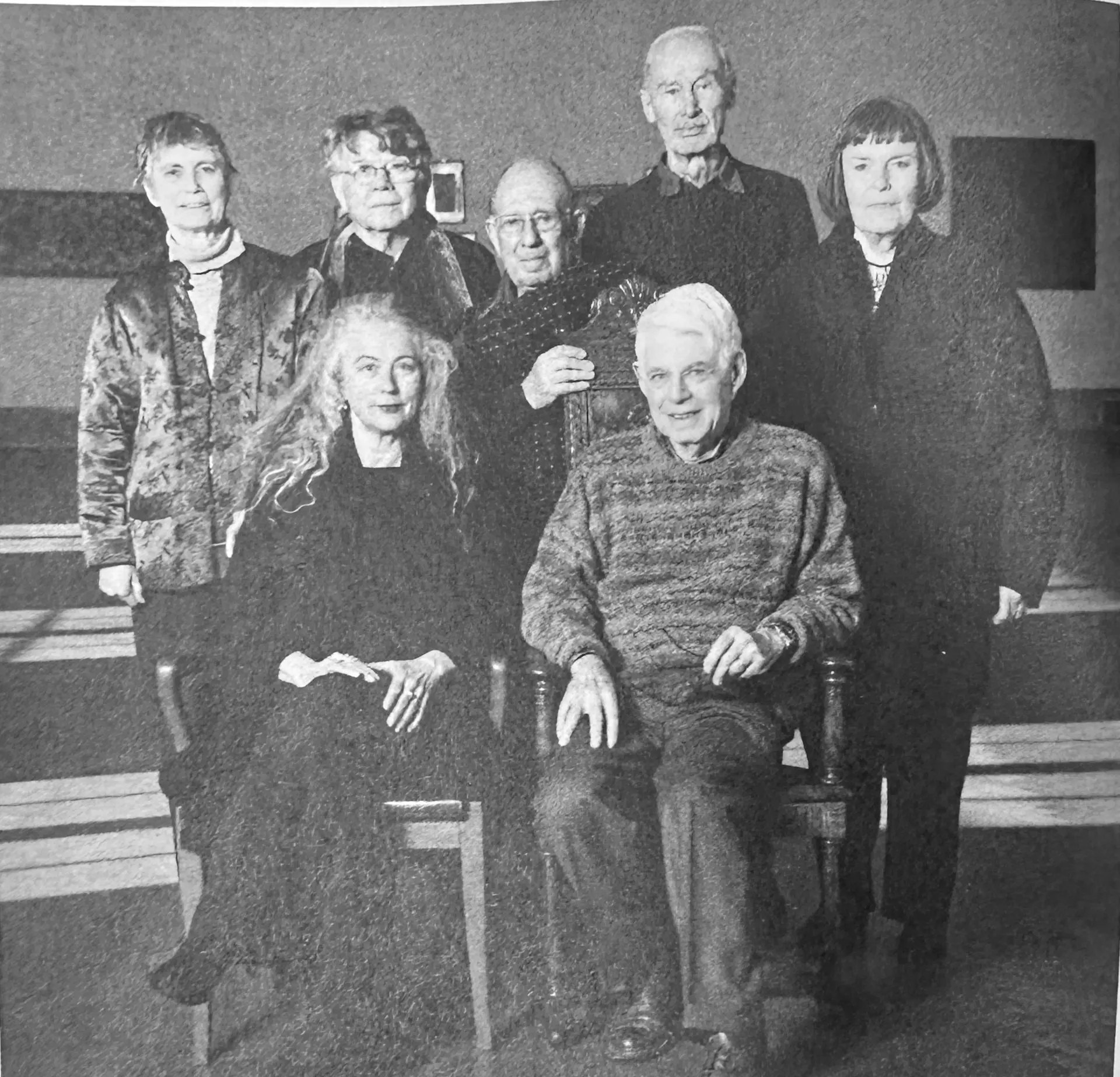 A group of people posing for a photograph. In the front, a man and woman sit beside each other in chairs. Three women and two men stand behind them.