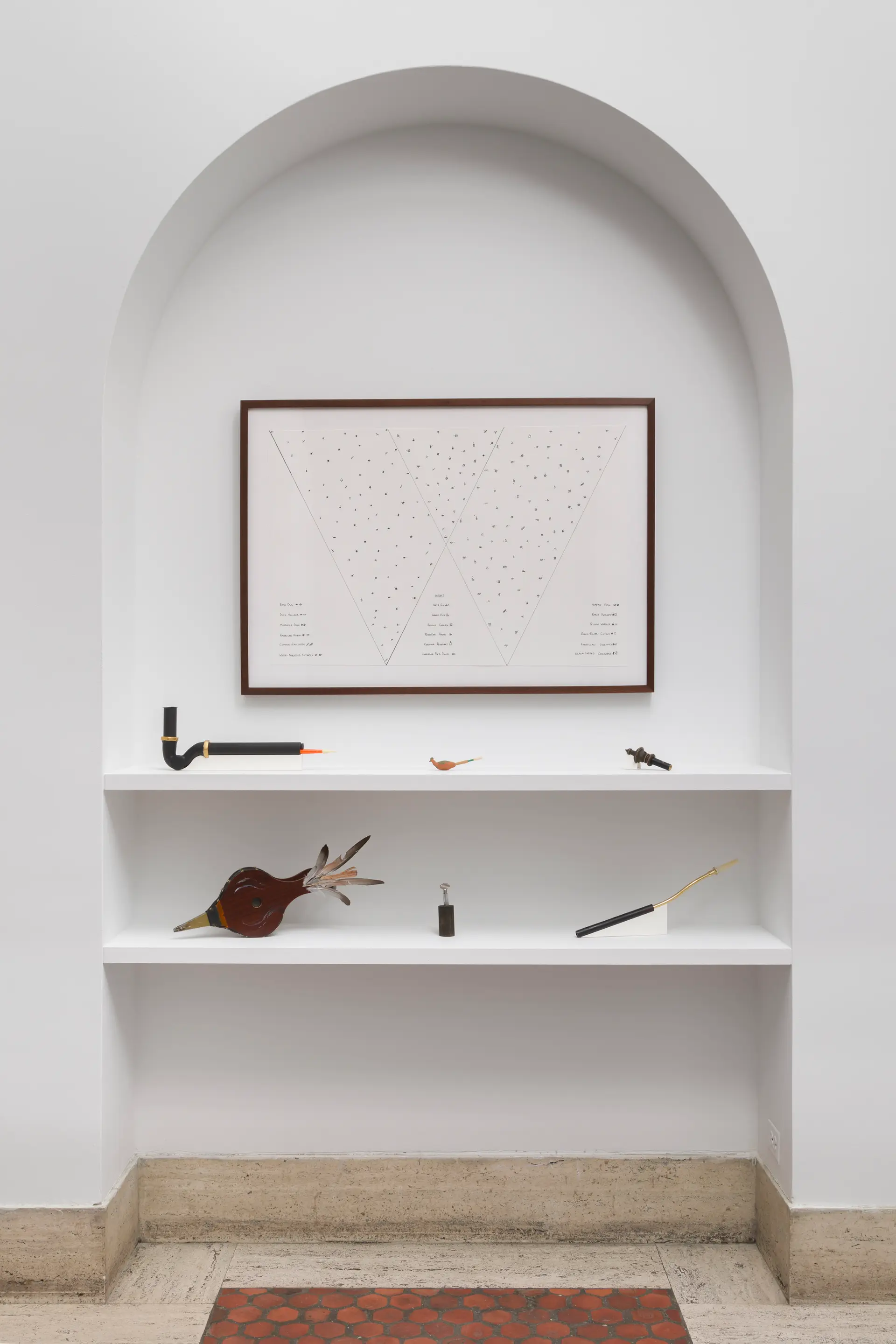 An arch cutout in the wall displayed a framed score and, on shelves, six bird calling instruments designed by Raven Chacon.