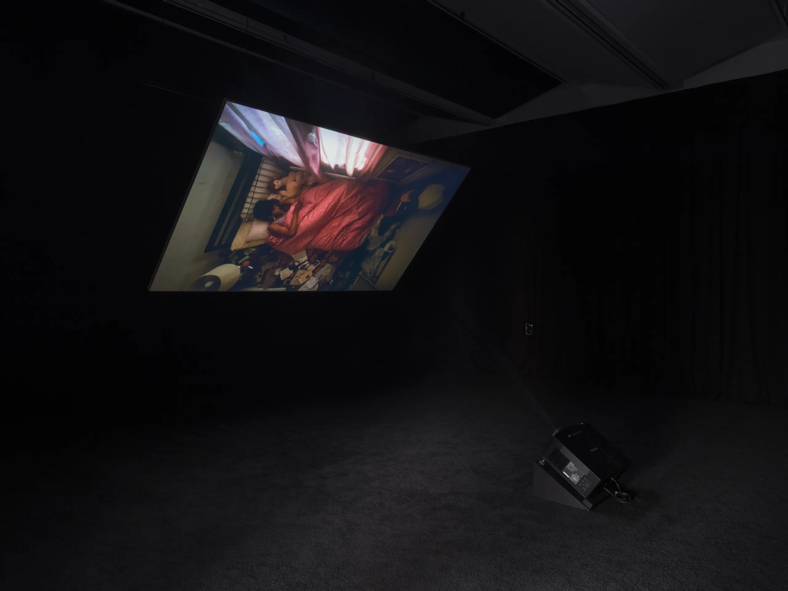 Installation view of video in a dark gallery