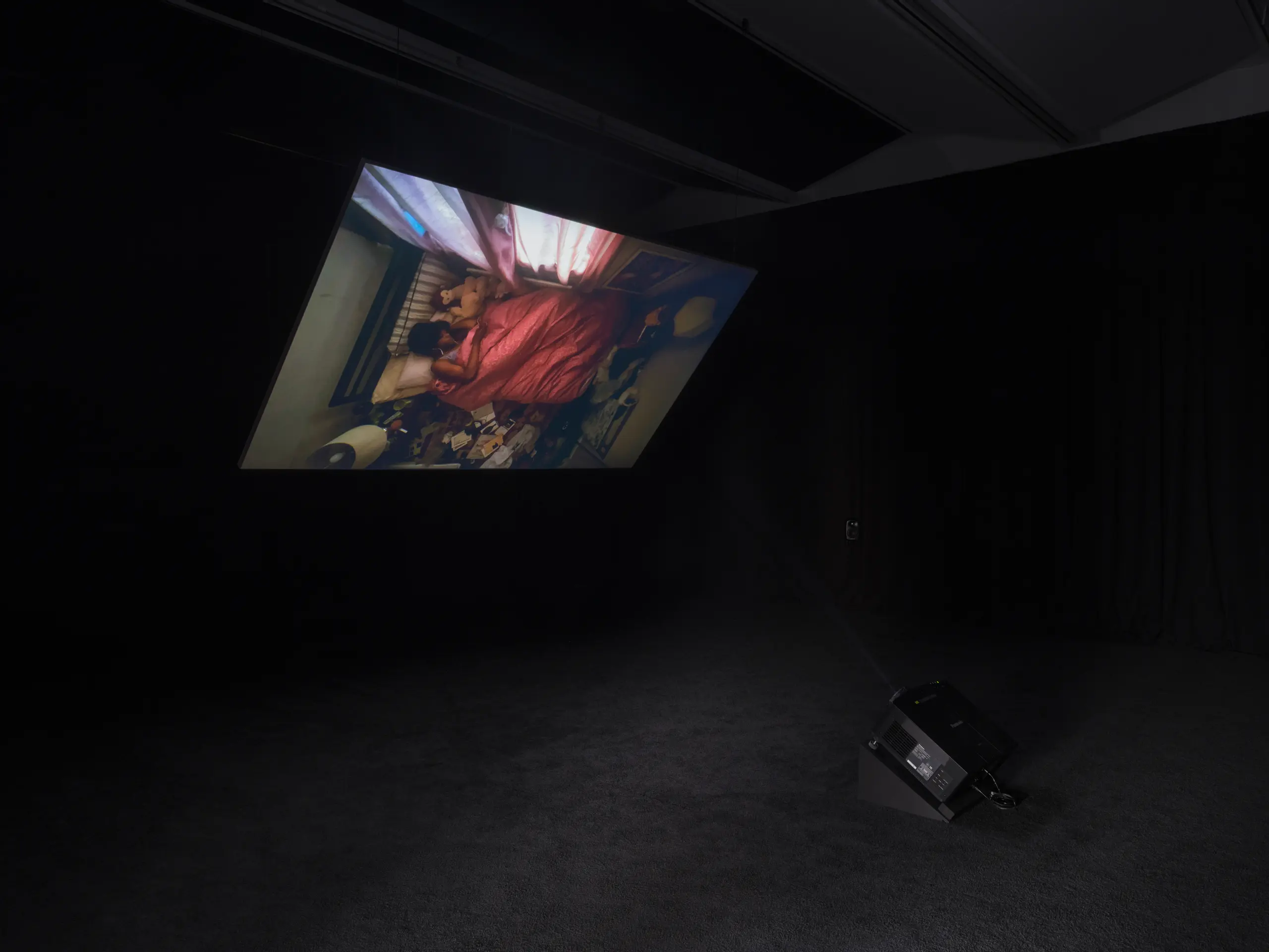 Installation view of video in a dark gallery