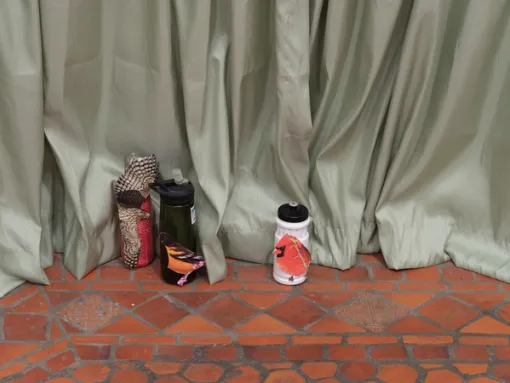 Water bottles in front of green curtain.